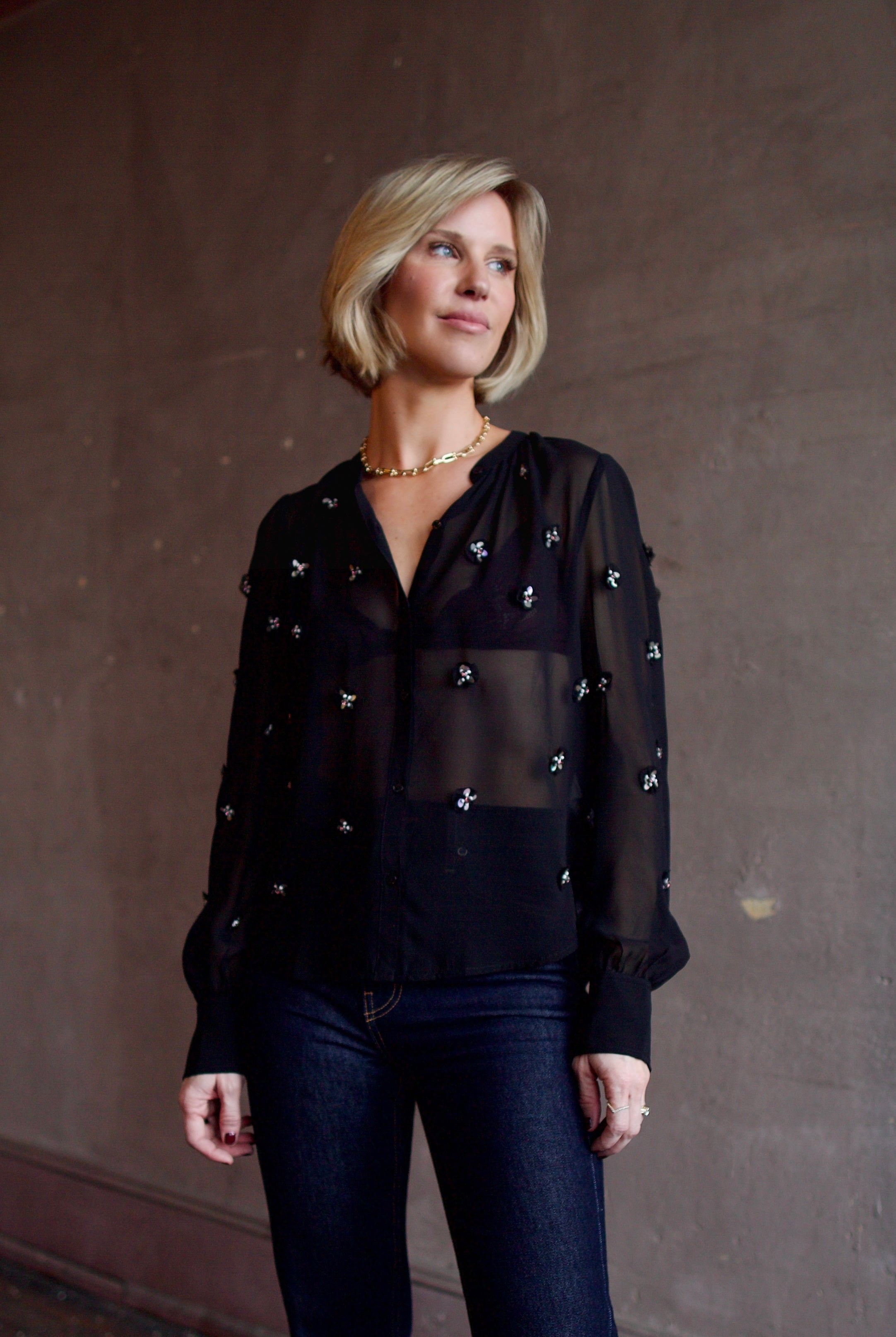 Image of woman wearing luxury designer Ulla Johnson Bea black sheer silk blouse in a button-front long sleeve
