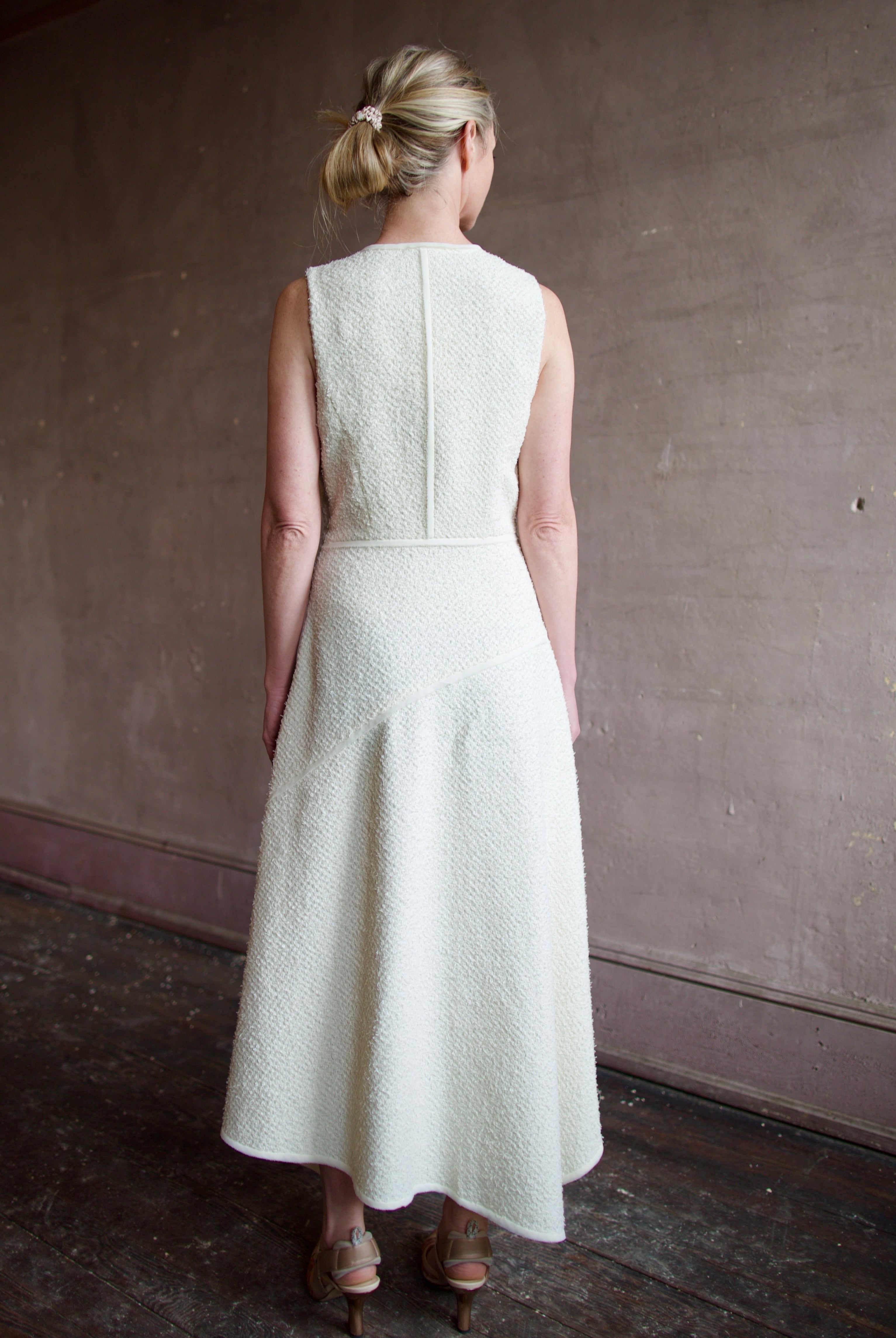 Woman wearing luxury designer Ulla Johnson Florence Dress in textured off-white cotton blend with a v-neckline and asymmetrical hemline