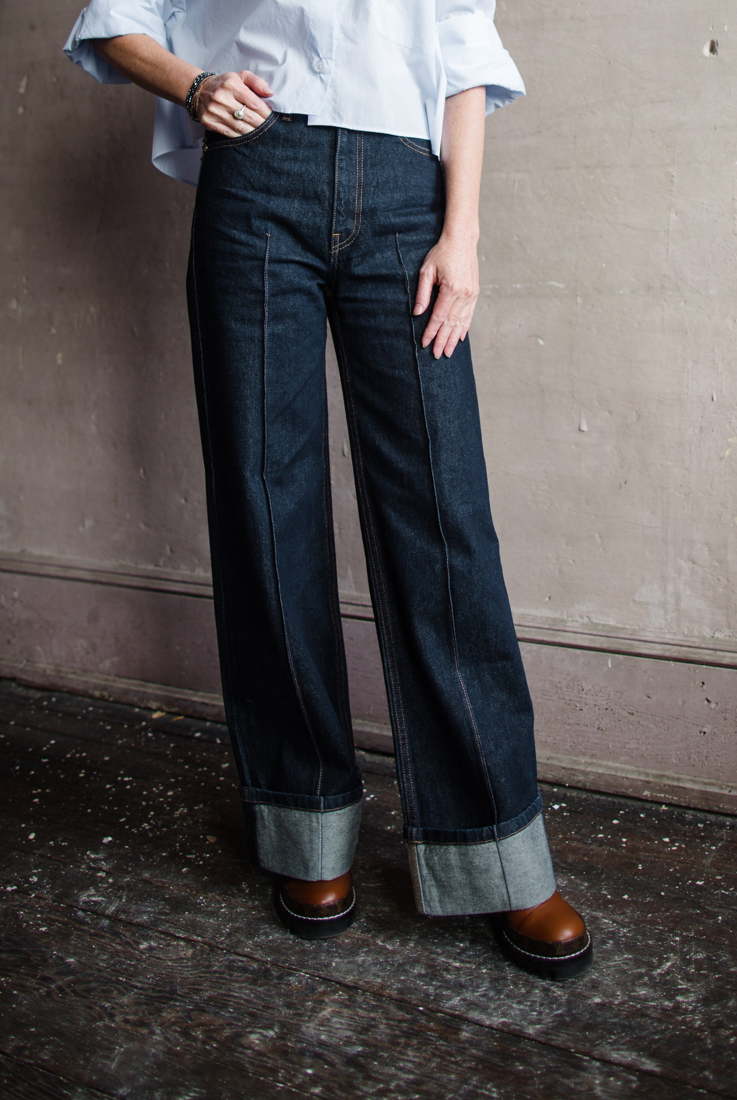 Image featuring a woman wearing Ulla Johnson Genevieve Jean with pintucking detail down middle front and back legs in a dark denim finish with no distressing.
