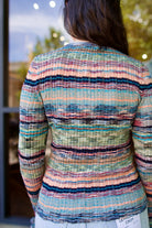 Model wearing a colorful striped Maci  ribbed knit pullover by contemporary luxury designer Ulla Johnson with blues, greens, and pinks