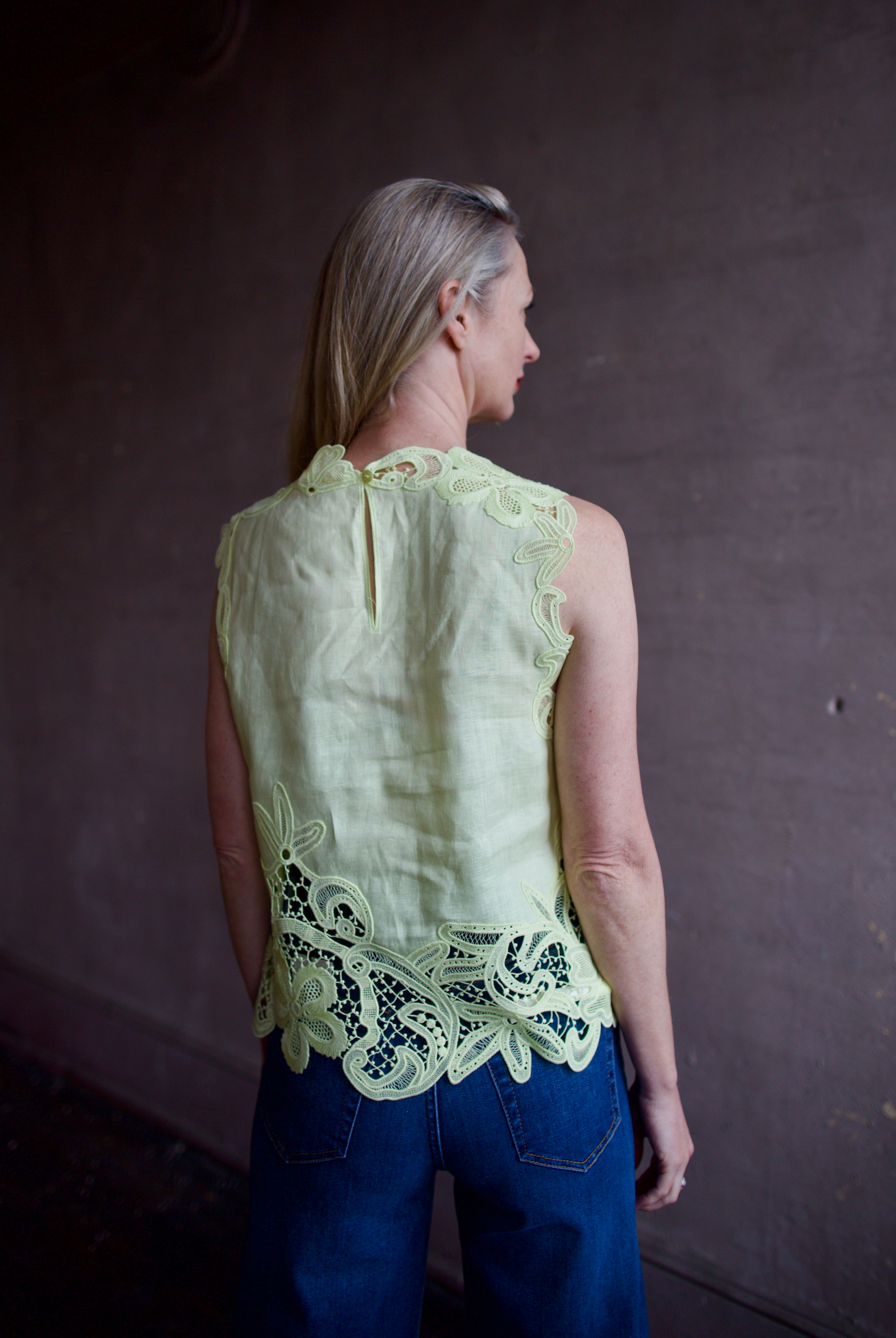 Mature woman wearing luxury designer Ulla Johnson Marlis premium linen top in citrine distinctive lace appliqué