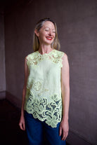 Mature woman wearing luxury designer Ulla Johnson Marlis premium linen top in citrine distinctive lace appliqué
