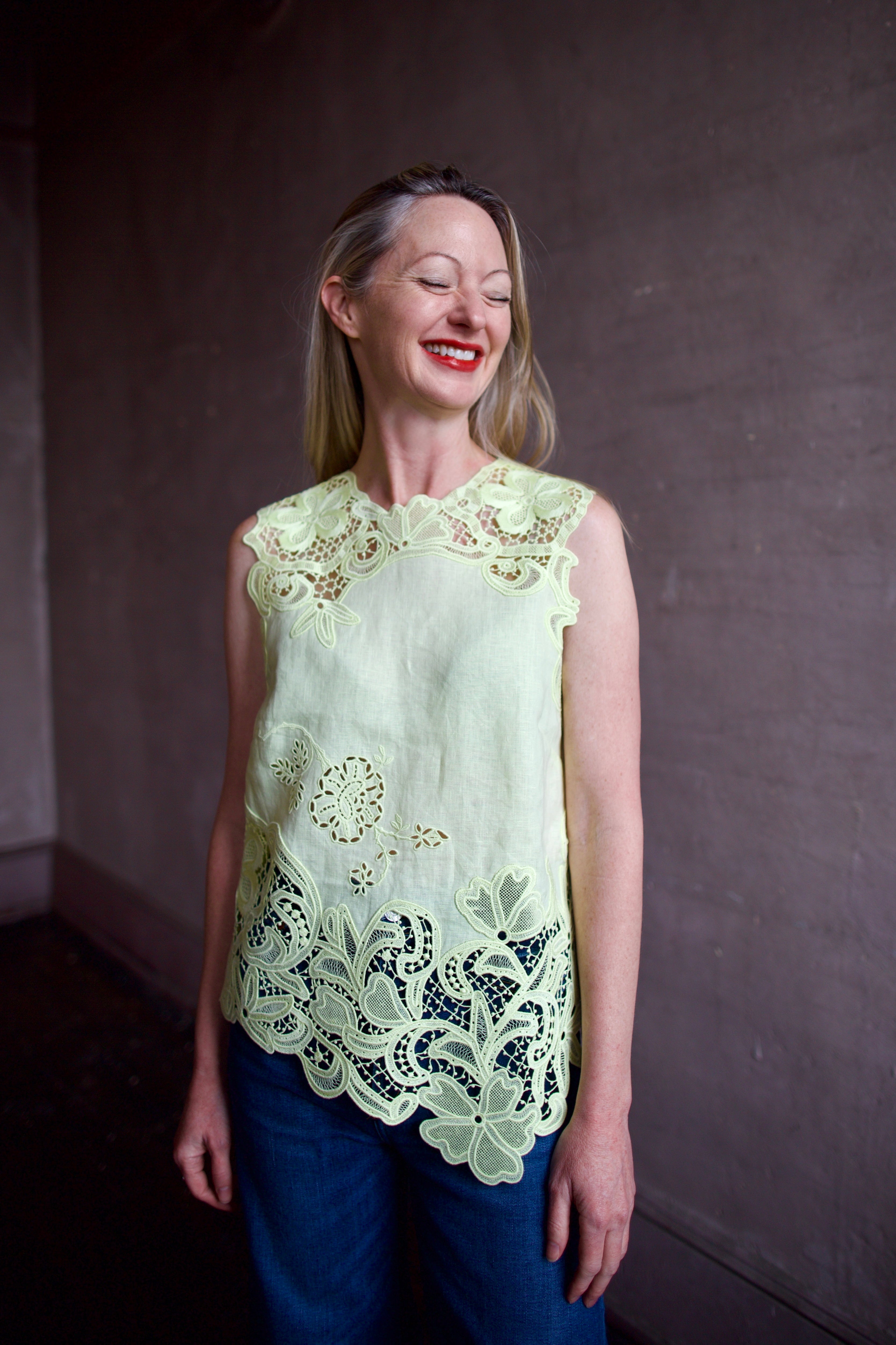 Mature woman wearing luxury designer Ulla Johnson Marlis premium linen top in citrine distinctive lace appliqué