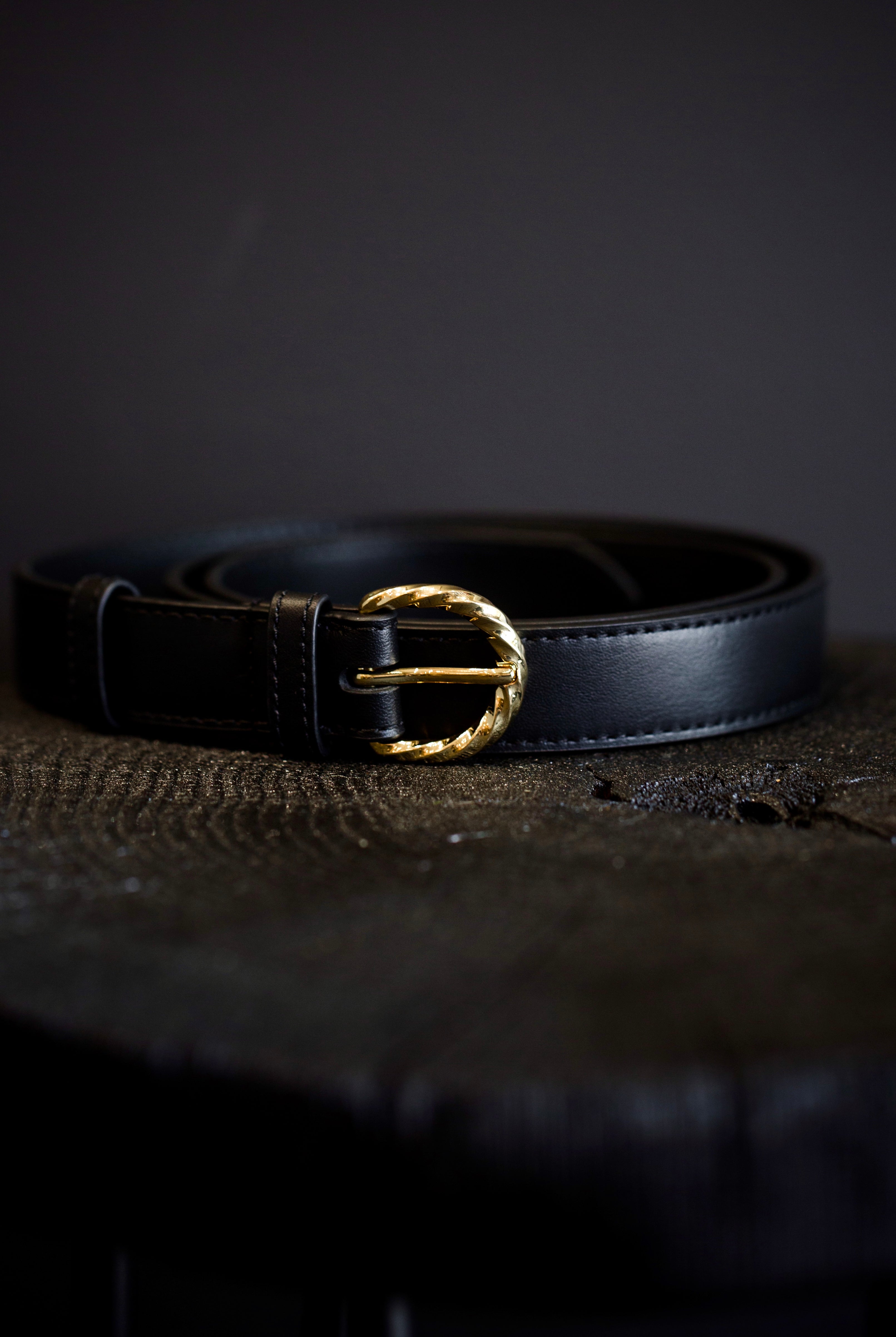 Black leather belt by high-end designer Ulla Johnson featuring a twisted gold buckle and smooth leather body.