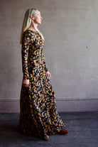 Model wearing the Amari dress from designer Ulla Johnson featuring long sleeves maxi length & fall patterned