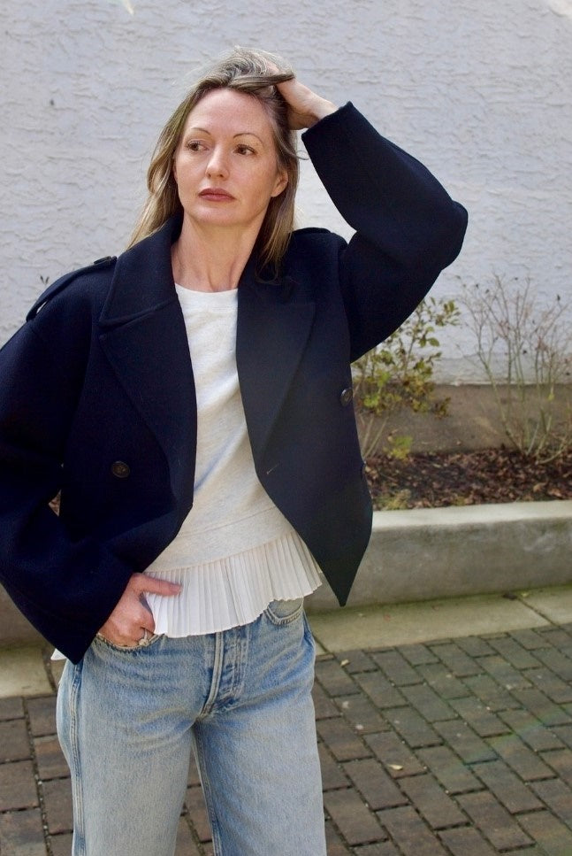 Mature woman wearing the Ulla Johnson Harper Top grey short sleeve sweatshirt with layered white top