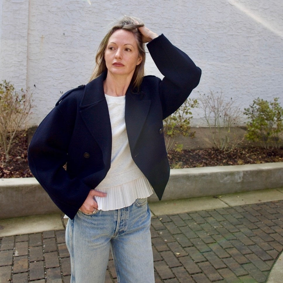 Mature woman wearing the Ulla Johnson Harper Top grey short sleeve sweatshirt with layered white top