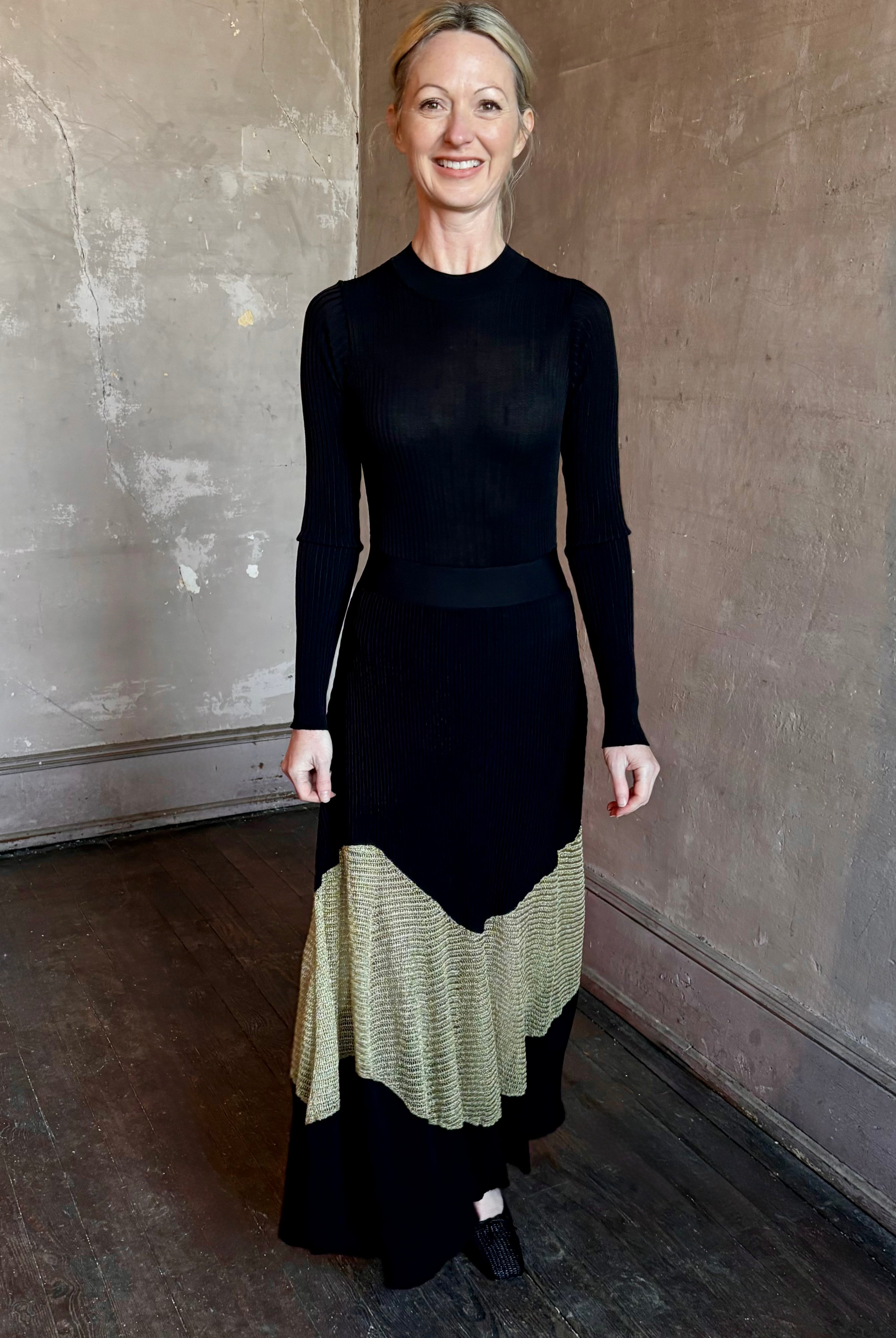 Image of woman wearing sophisticated Ulla Johnson Roanne knit maxi A-Line Dress with elegant sheer gold chevron detail and long sleeves