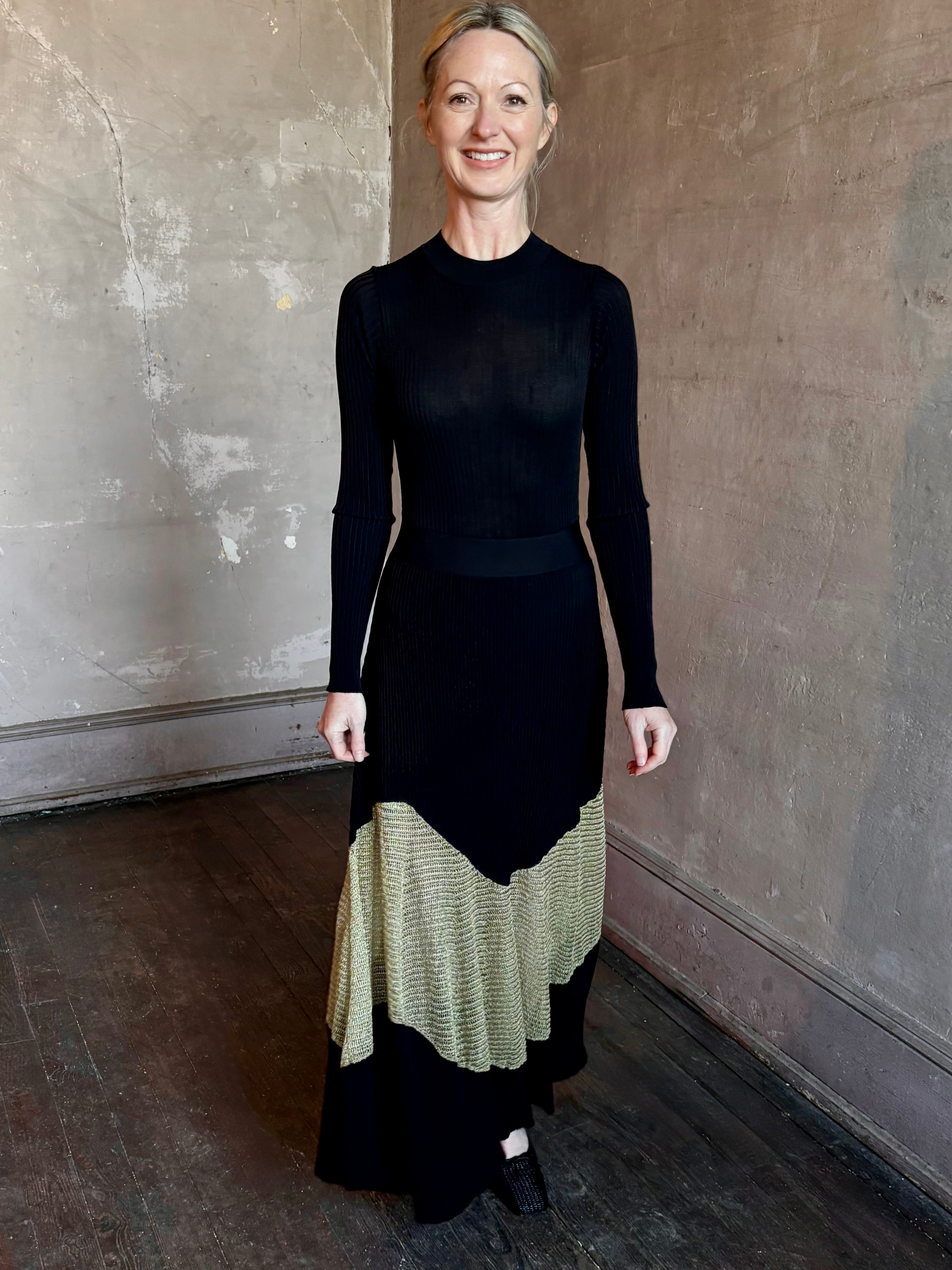 Image of woman wearing sophisticated Ulla Johnson Roanne knit maxi A-Line Dress with elegant sheer gold chevron detail and long sleeves