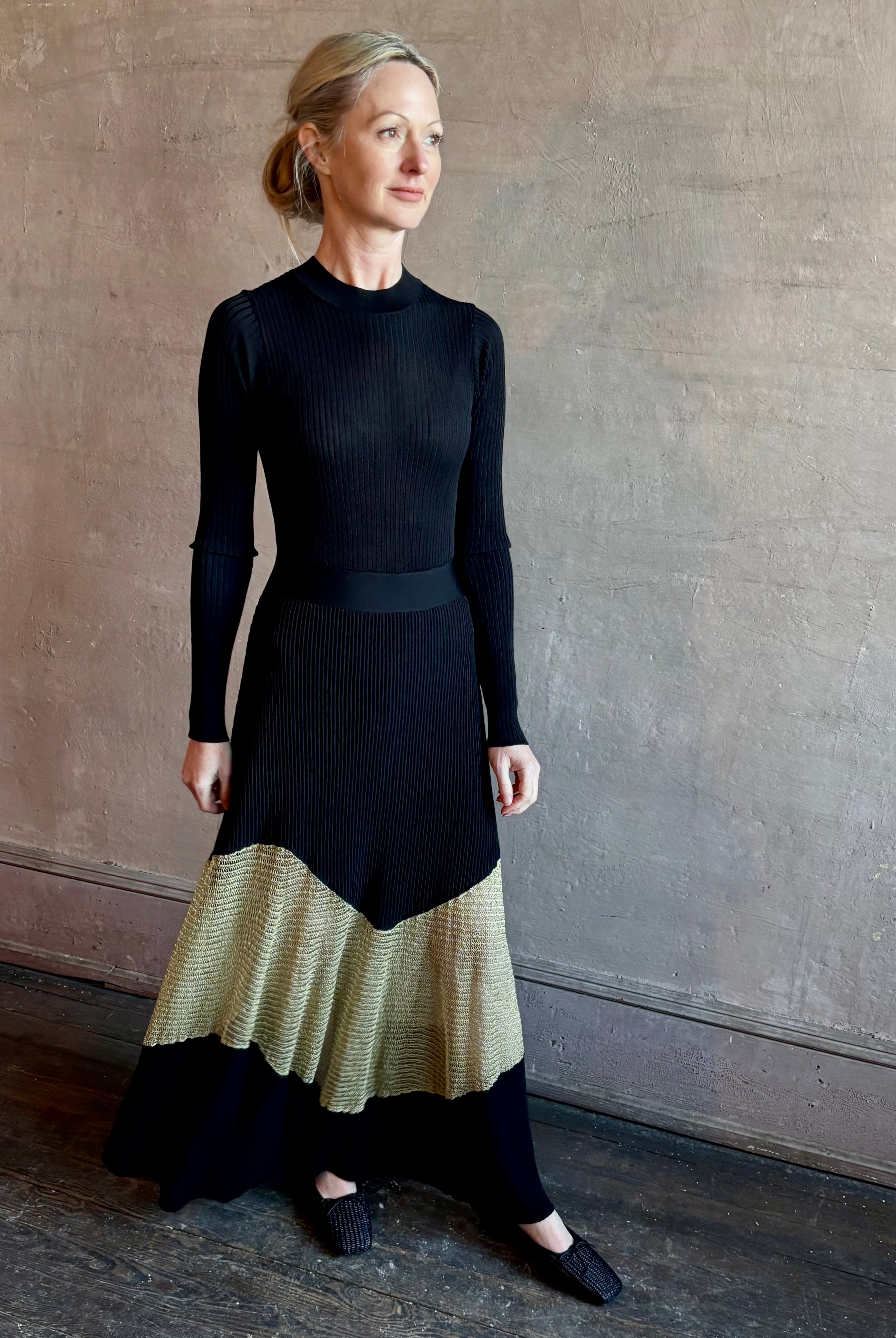 Image of woman wearing sophisticated Ulla Johnson Roanne knit maxi A-Line Dress with elegant sheer gold chevron detail and long sleeves