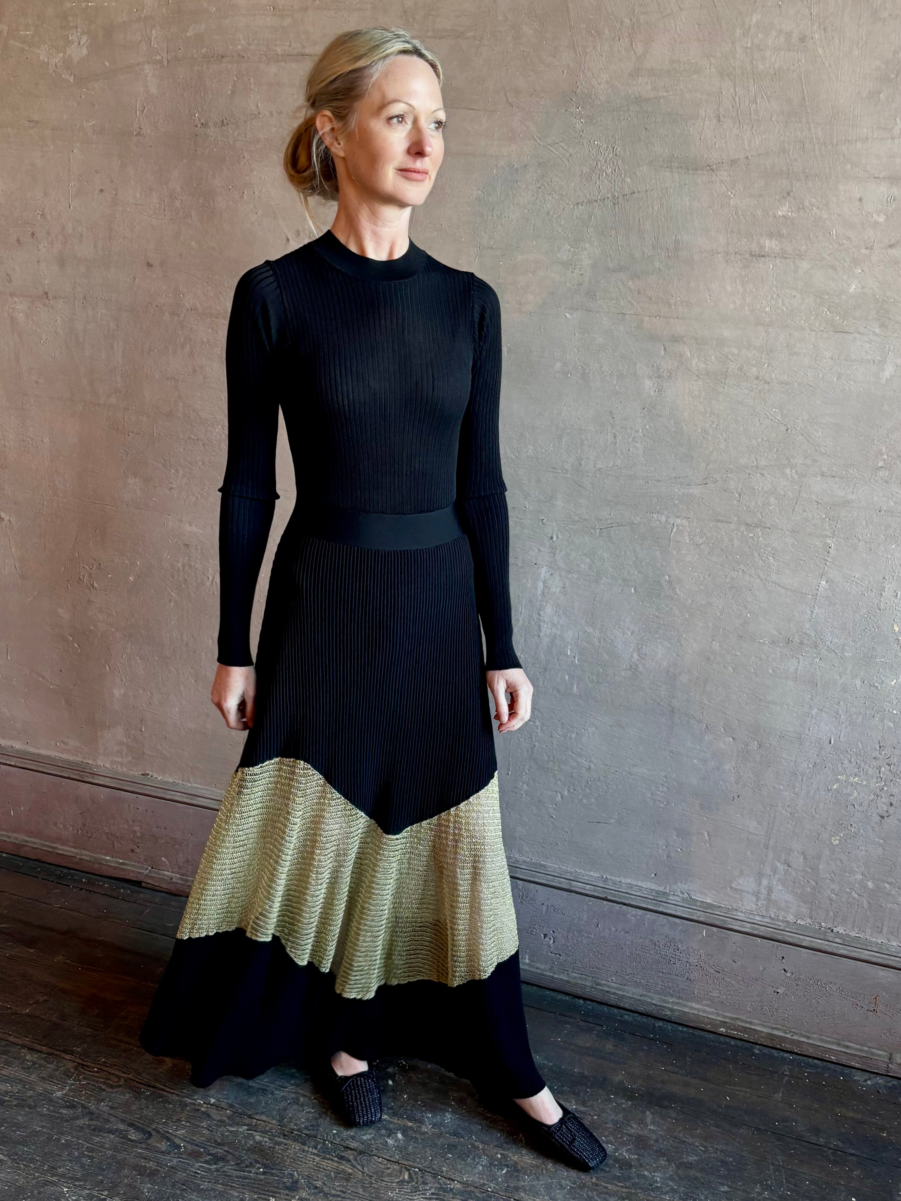 Image of woman wearing sophisticated Ulla Johnson Roanne knit maxi A-Line Dress with elegant sheer gold chevron detail and long sleeves