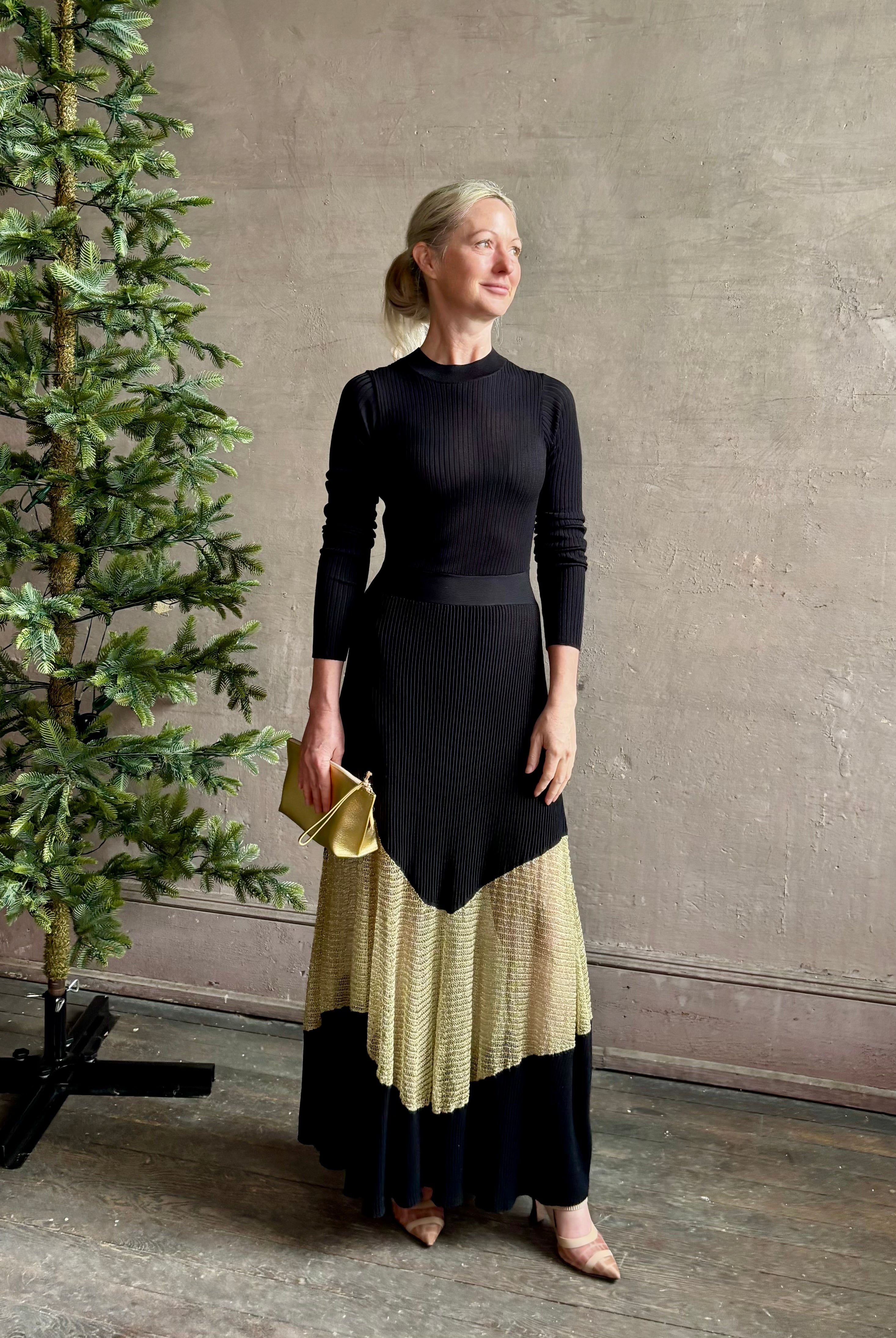 Image of woman wearing sophisticated Ulla Johnson Roanne knit maxi A-Line Dress with elegant sheer gold chevron detail and long sleeves