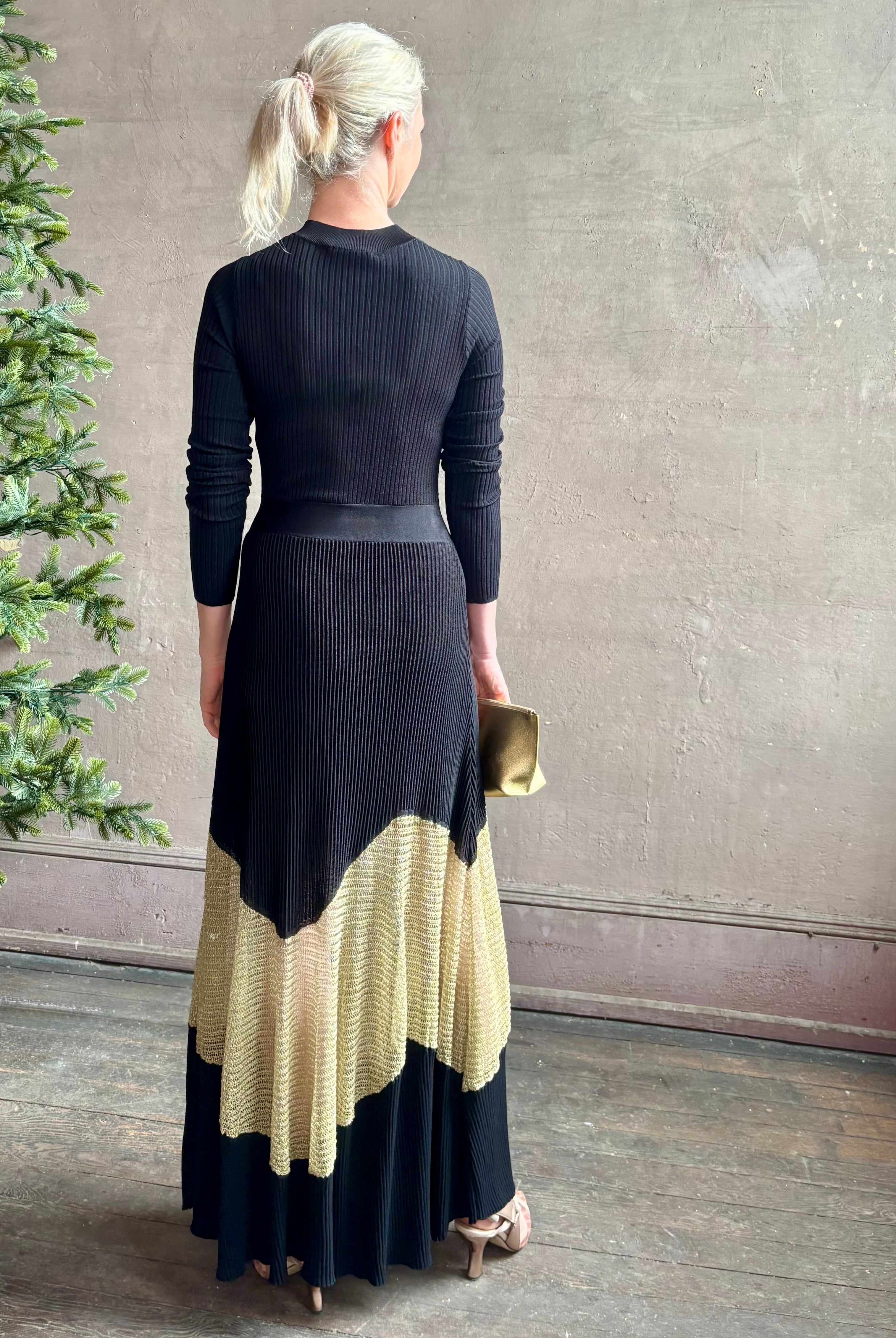 Image of woman wearing sophisticated Ulla Johnson Roanne knit maxi A-Line Dress with elegant sheer gold chevron detail and long sleeves