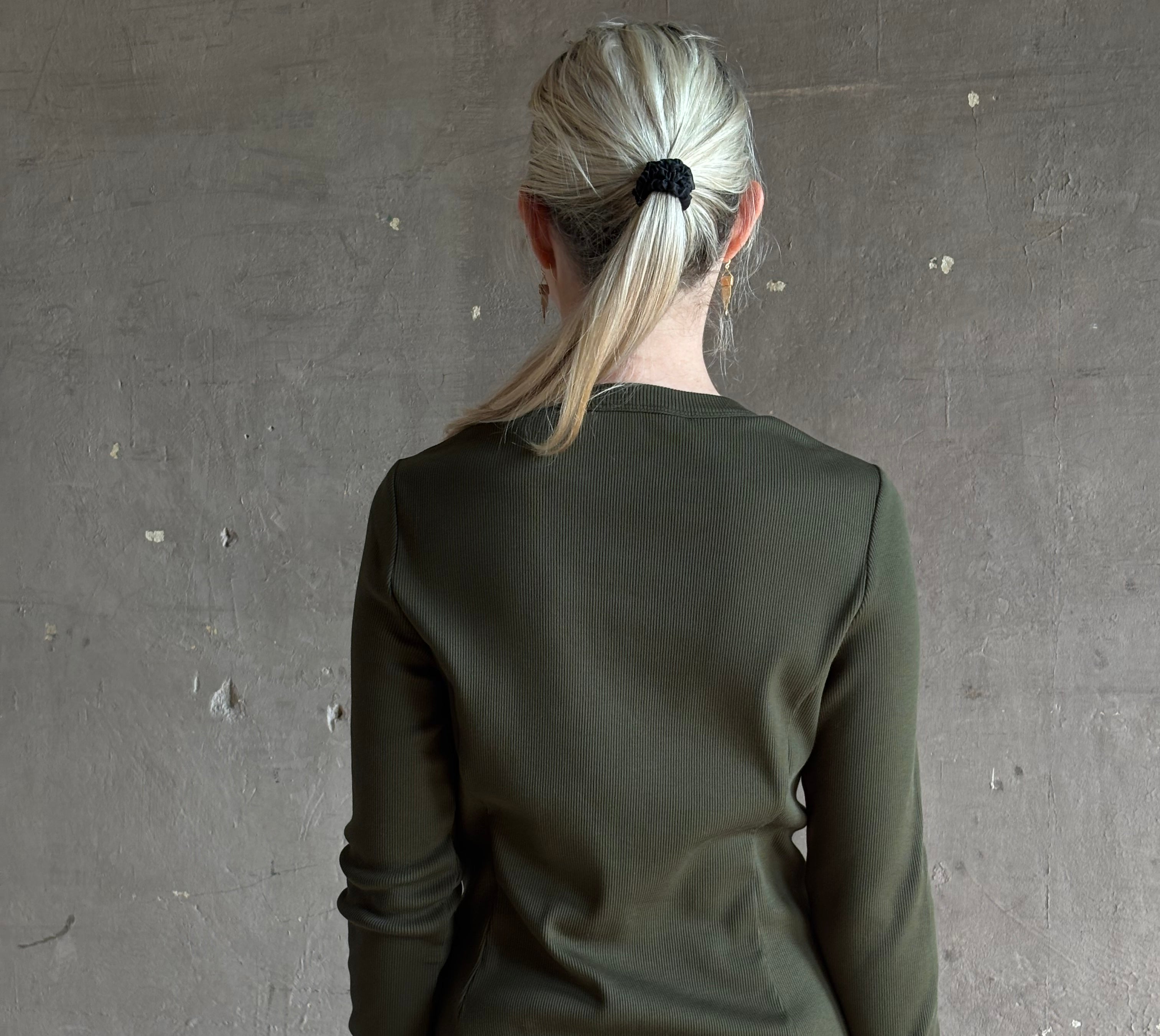 Mature womanwearing a dark green long-sleeve ribbed cotton henley top designer Veronica Beard Cordis Long Sleeves