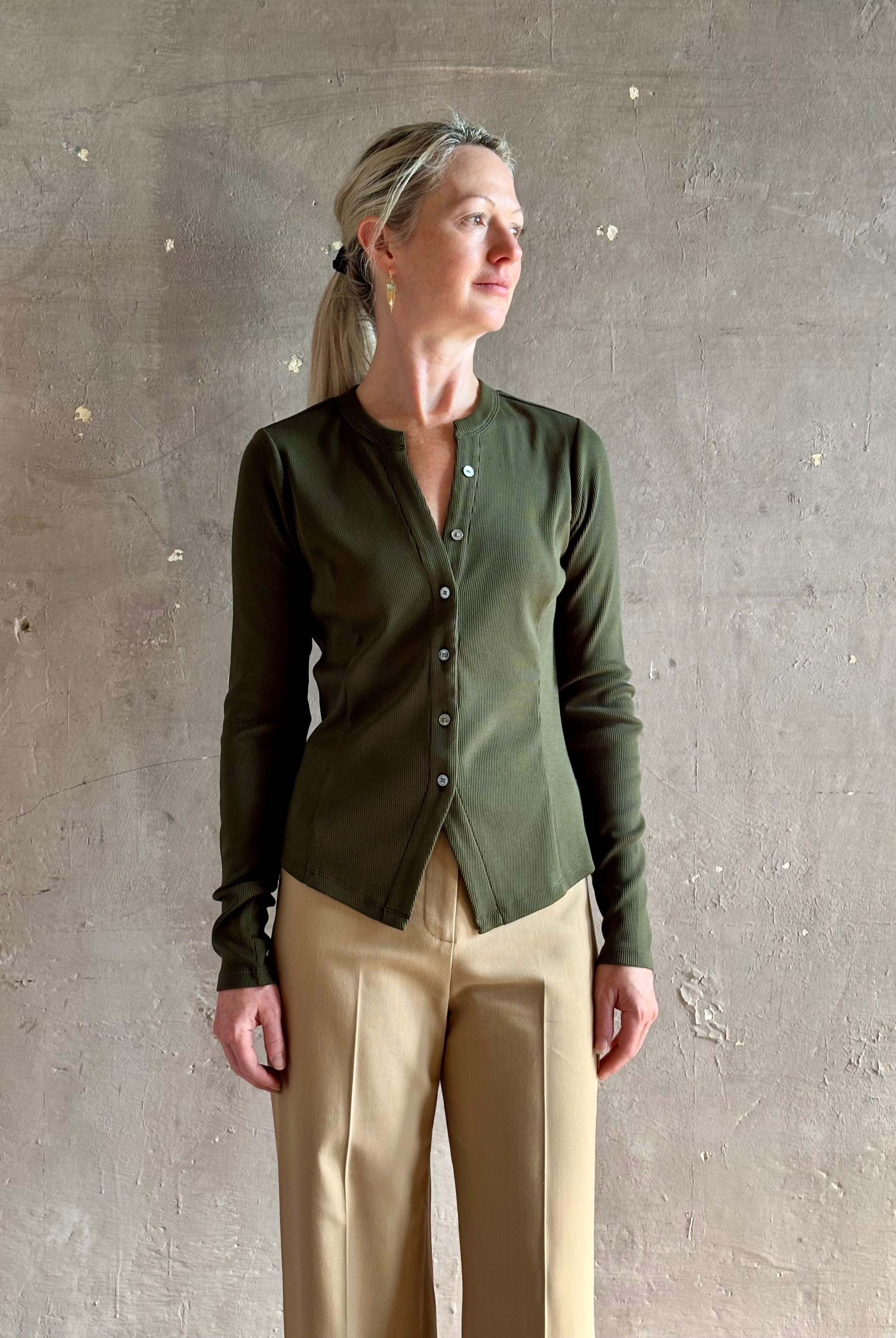 Mature womanwearing a dark green long-sleeve ribbed cotton henley top designer Veronica Beard Cordis v-neck