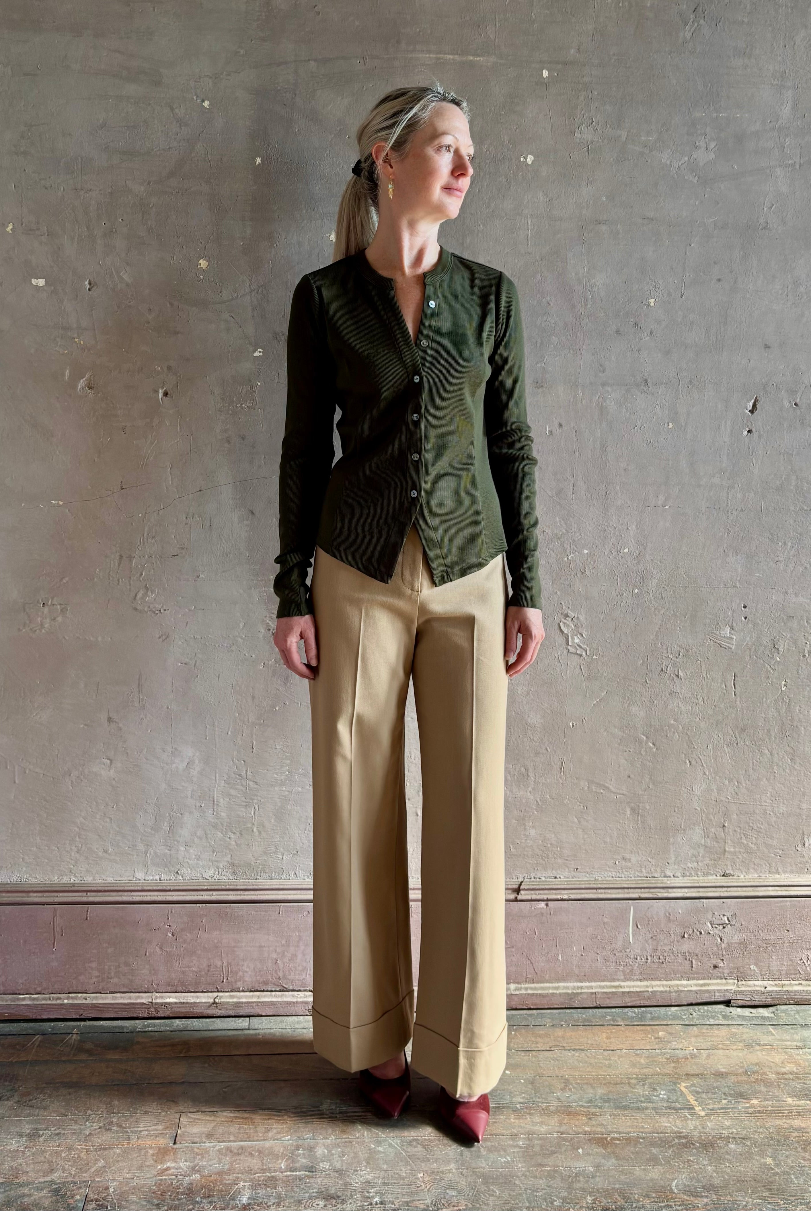Mature womanwearing a dark green long-sleeve ribbed cotton henley top designer Veronica Beard Cordis v-neck
