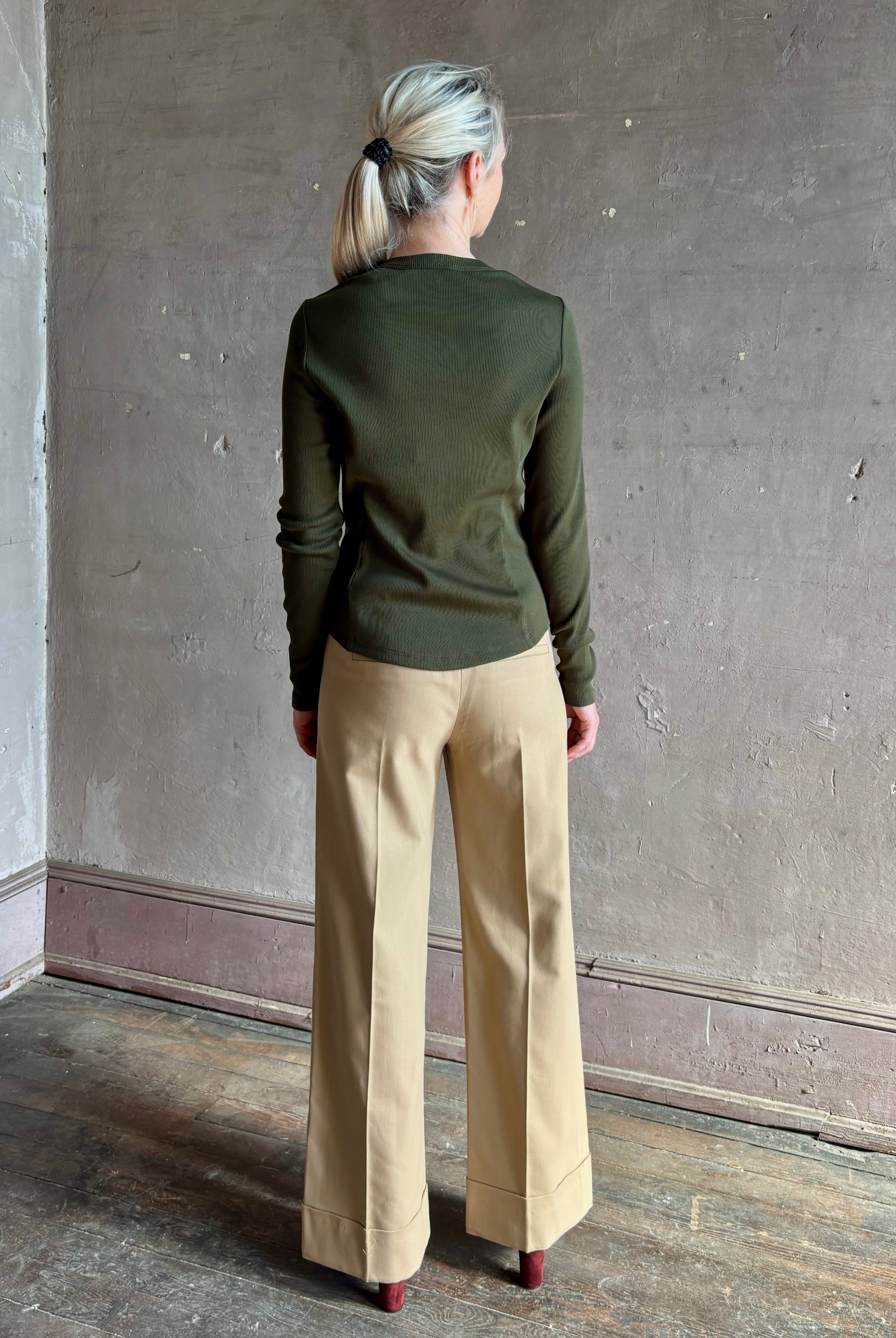 Mature womanwearing a dark green long-sleeve ribbed cotton henley top designer Veronica Beard Cordis Long Sleeves
