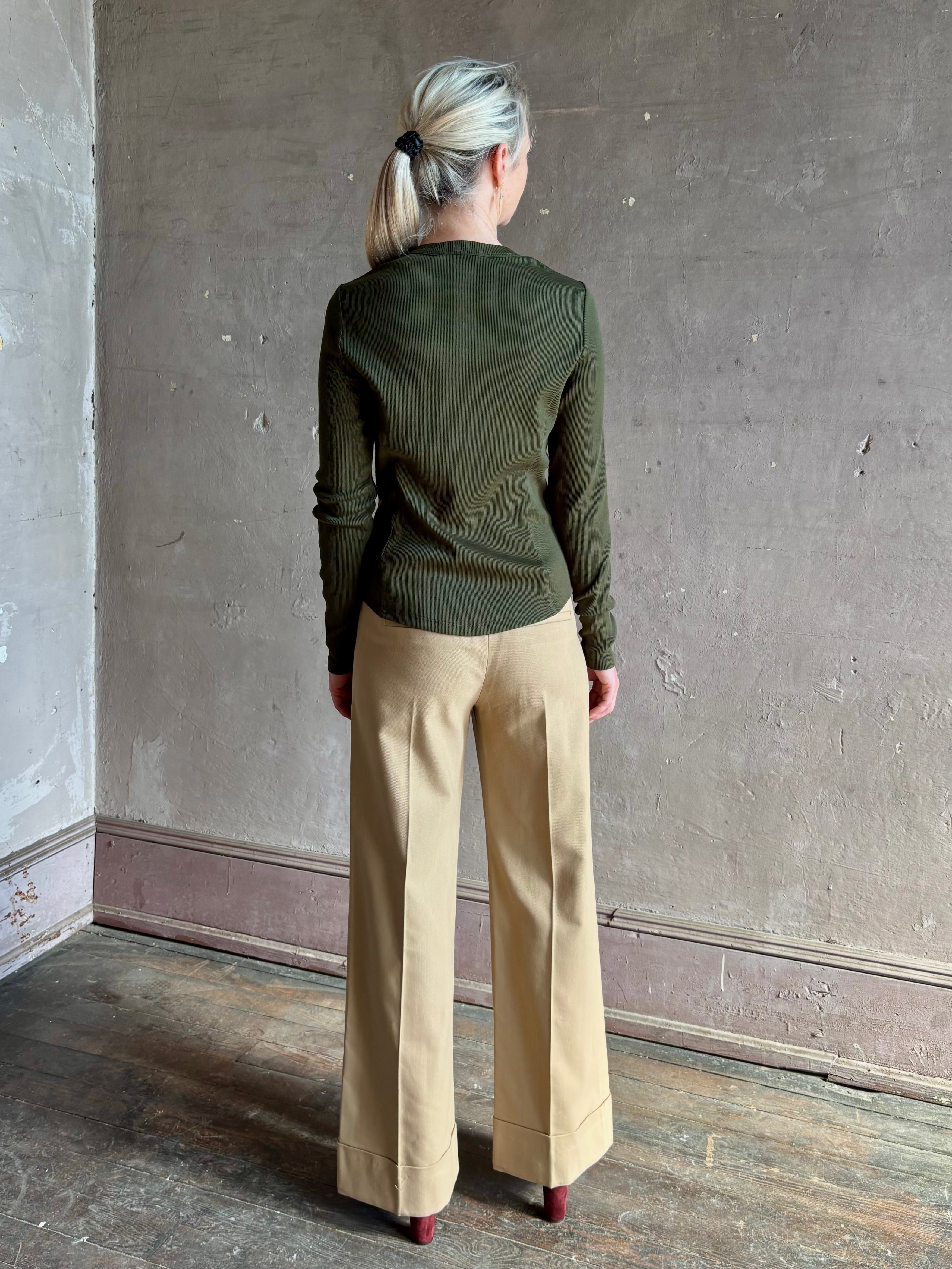 Mature womanwearing a dark green long-sleeve ribbed cotton henley top designer Veronica Beard Cordis Long Sleeves