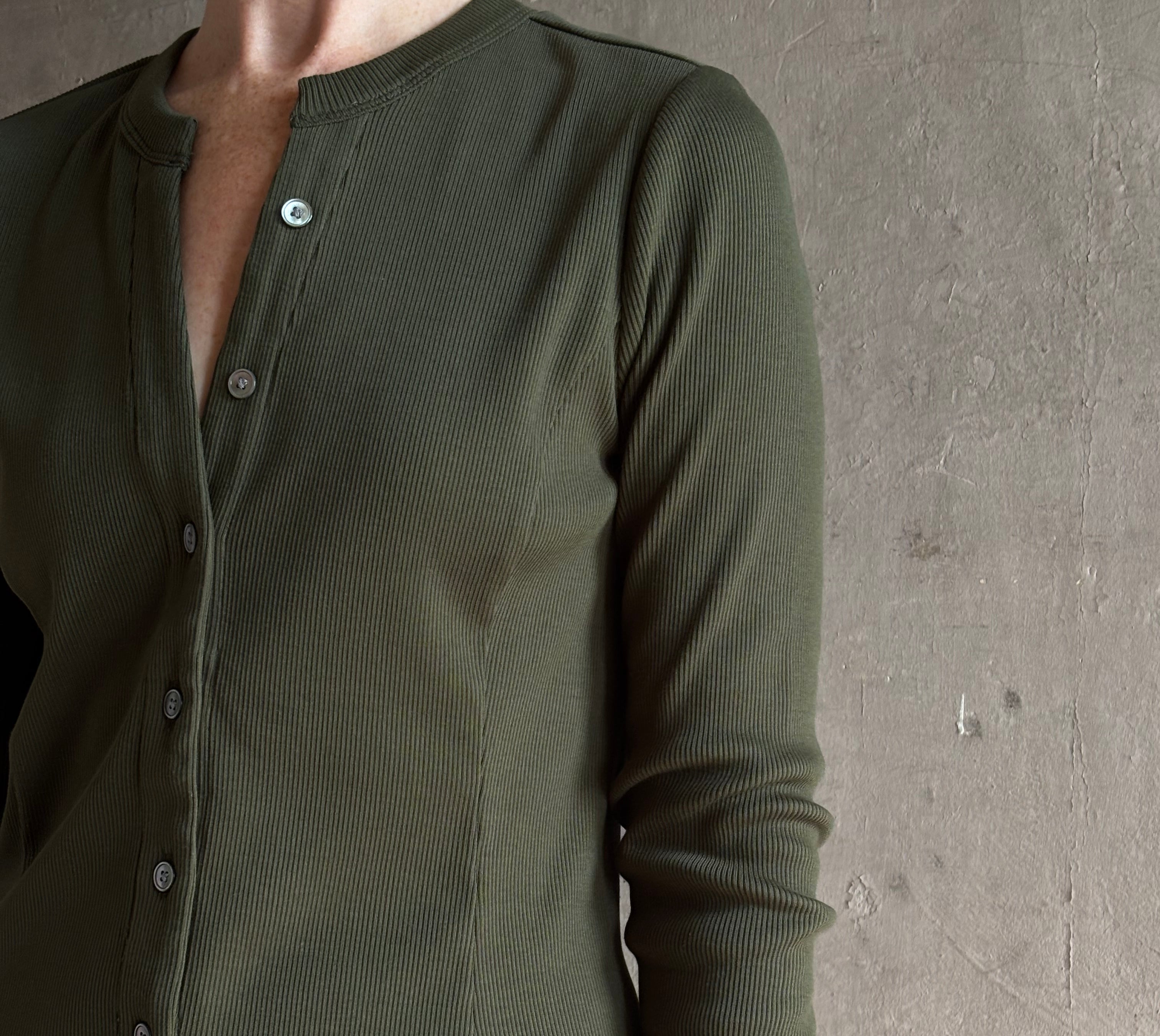 Mature womanwearing a dark green long-sleeve ribbed cotton henley top designer Veronica Beard Cordisv-neck