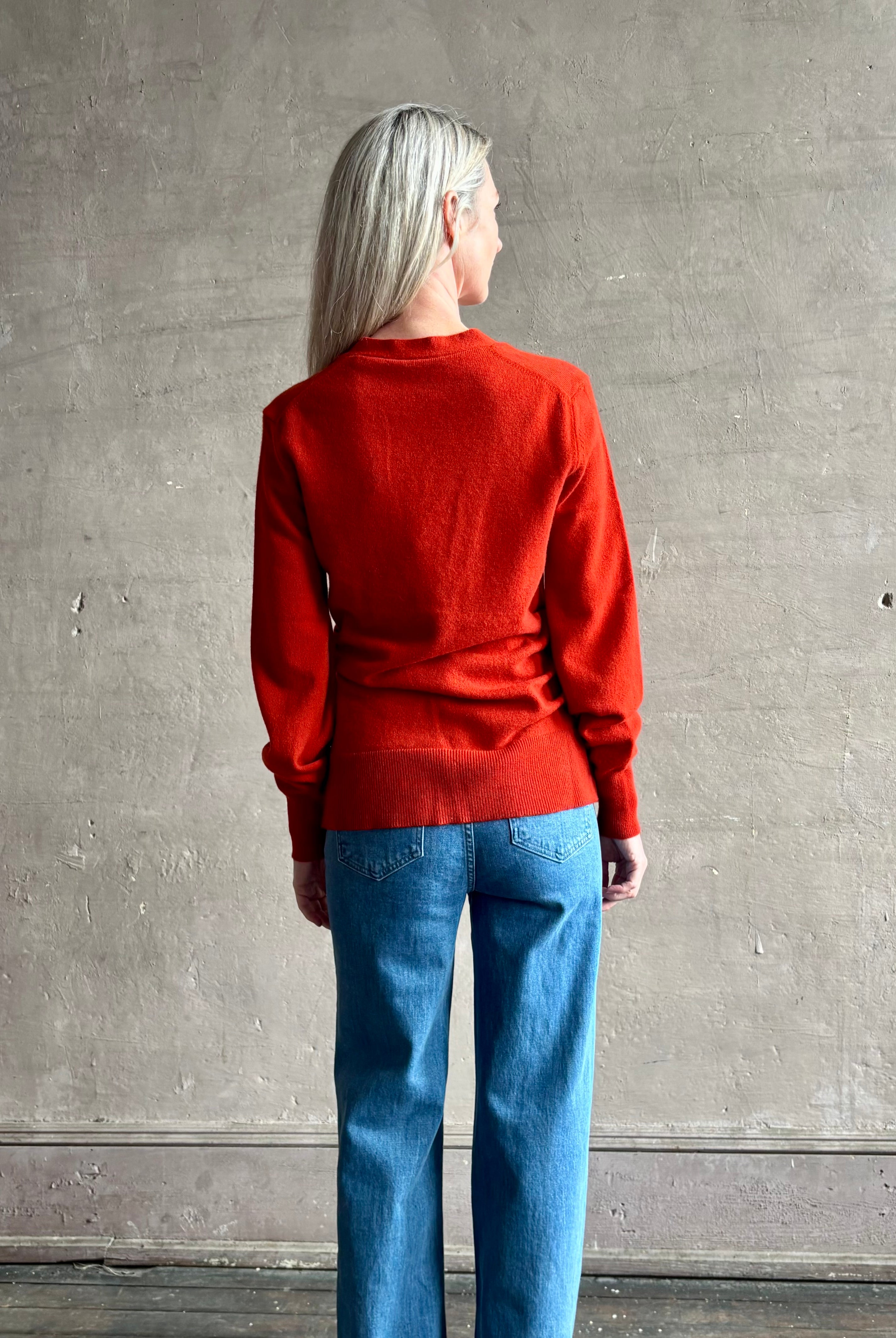 Woman wearing VERONICA BEARD Lamotte Cashmere Cardigan in a orange Red with long sleeves