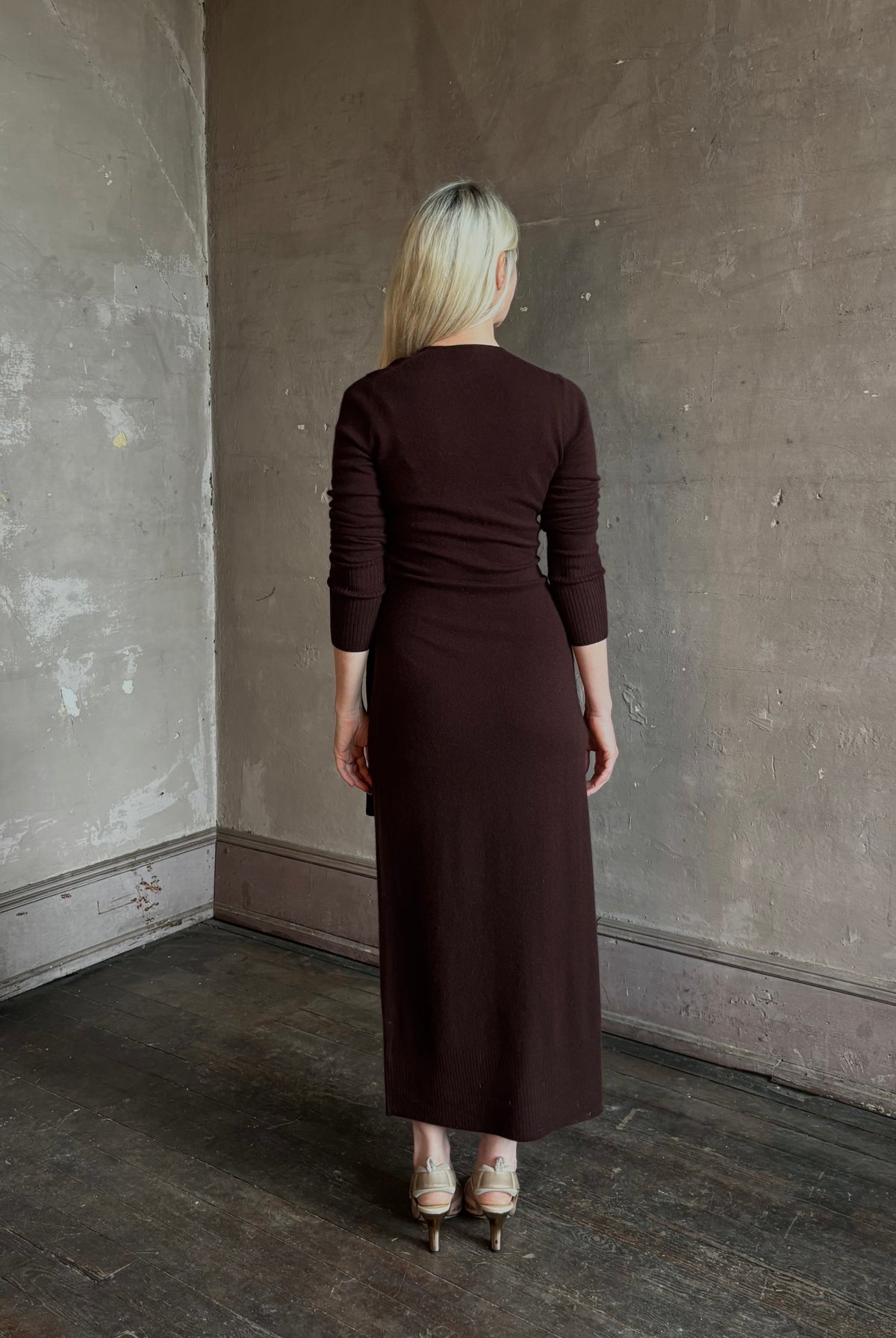 Mature woman wearing Veronica Beard's Salomez Knit Dress in chocolate brown wrap maxi with a V-neckline and side vent