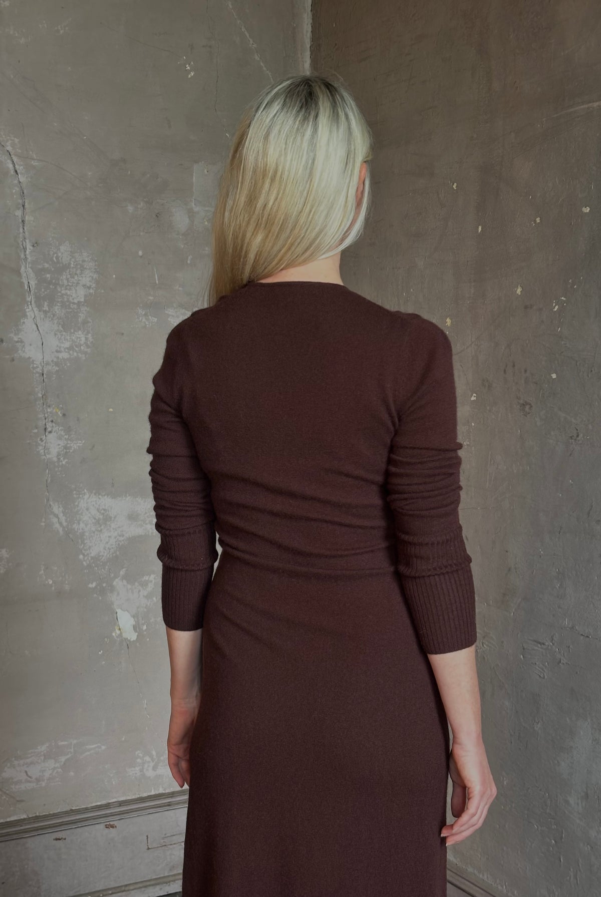 Mature woman wearing Veronica Beard's Salomez Knit Dress in chocolate brown wrap maxi with a V-neckline and side vent