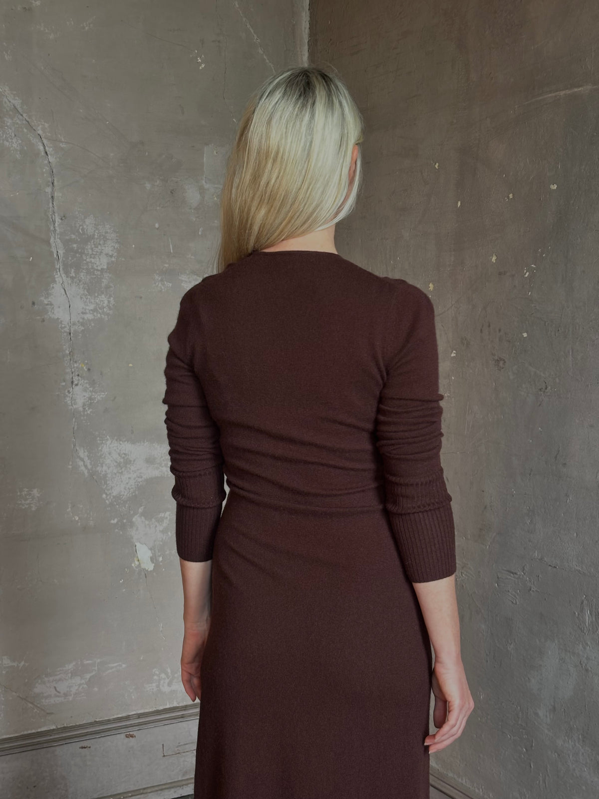 Mature woman wearing Veronica Beard's Salomez Knit Dress in chocolate brown wrap maxi with a V-neckline and side vent