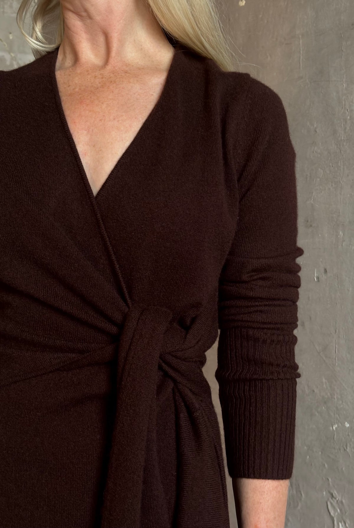 Mature woman wearing Veronica Beard's Salomez Knit Dress in chocolate brown wrap maxi with a V-neckline and side vent