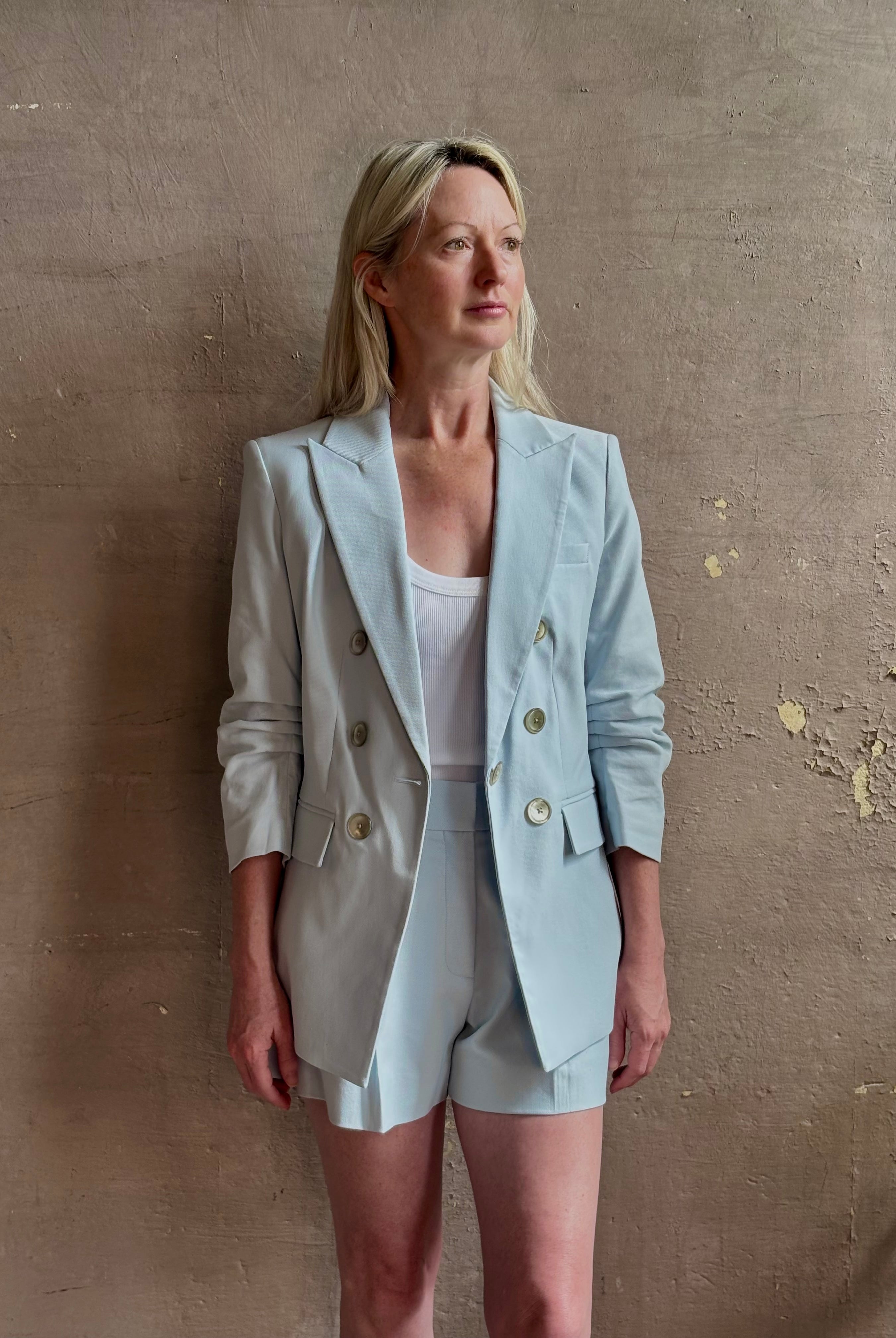 Mature woman wearing tailored Veronica Beard Tomi Dickey Jacket light blue cotton viscose blend ruched sleeves