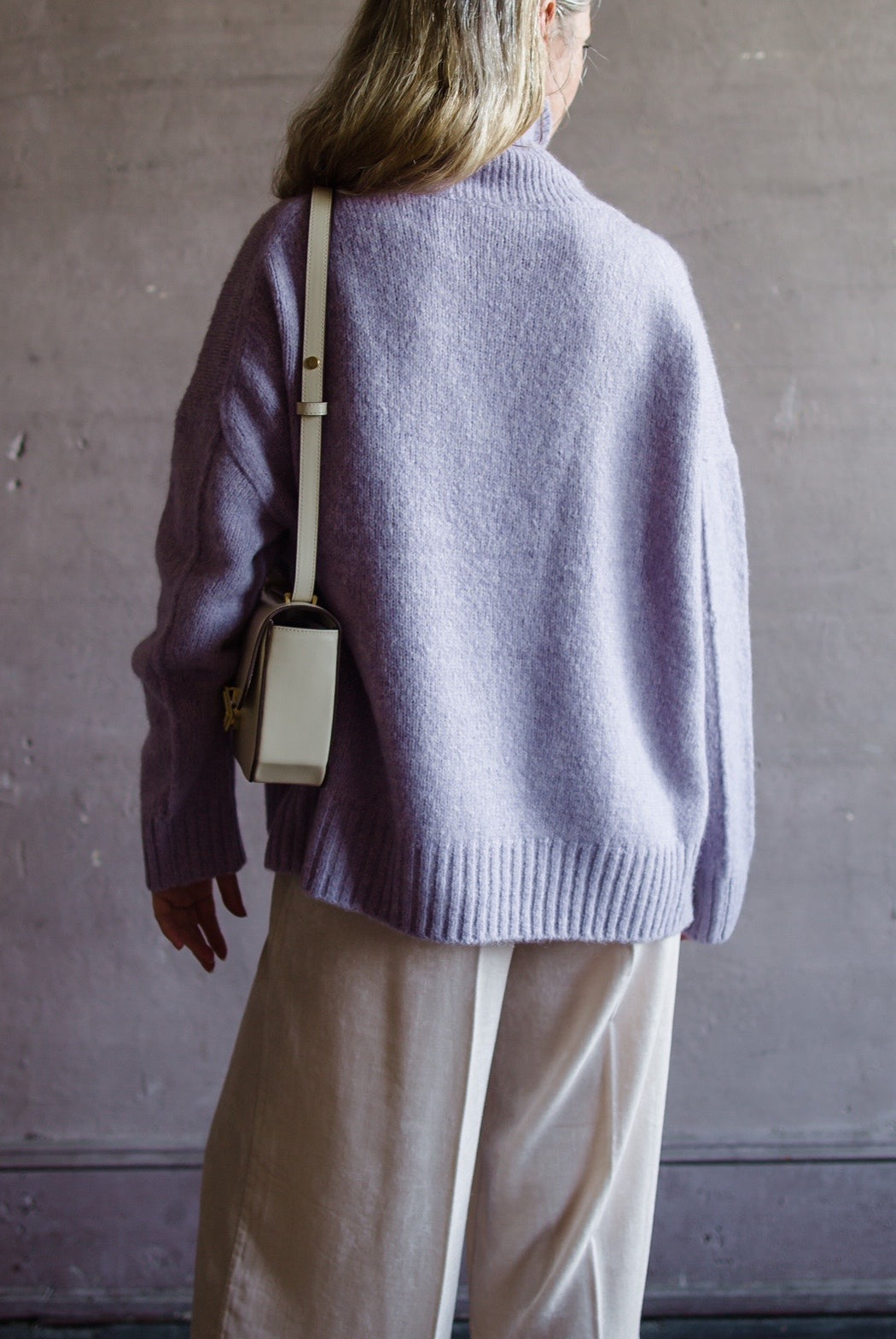 Image featuring a woman wearing the Balade yack, alpaca & wool sweater by Vanessa Bruno with a high neckline with a front seam and oversized fit in lilac color.