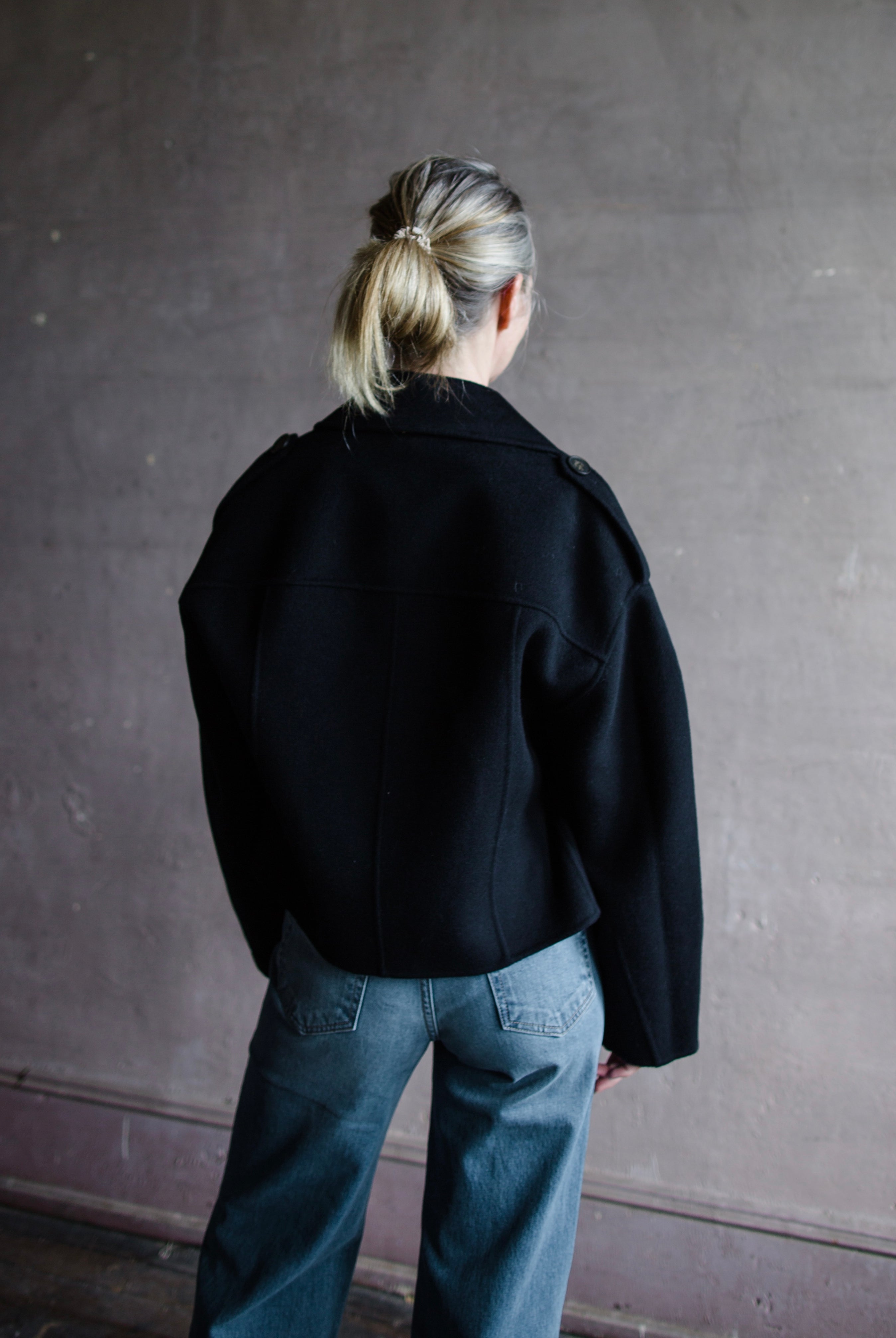 Image featuring a woman wearing the Beran jacket by Vanessa Bruno with double breasted button closure and a full sleeve with a slightly shorter fit in navy blue.
