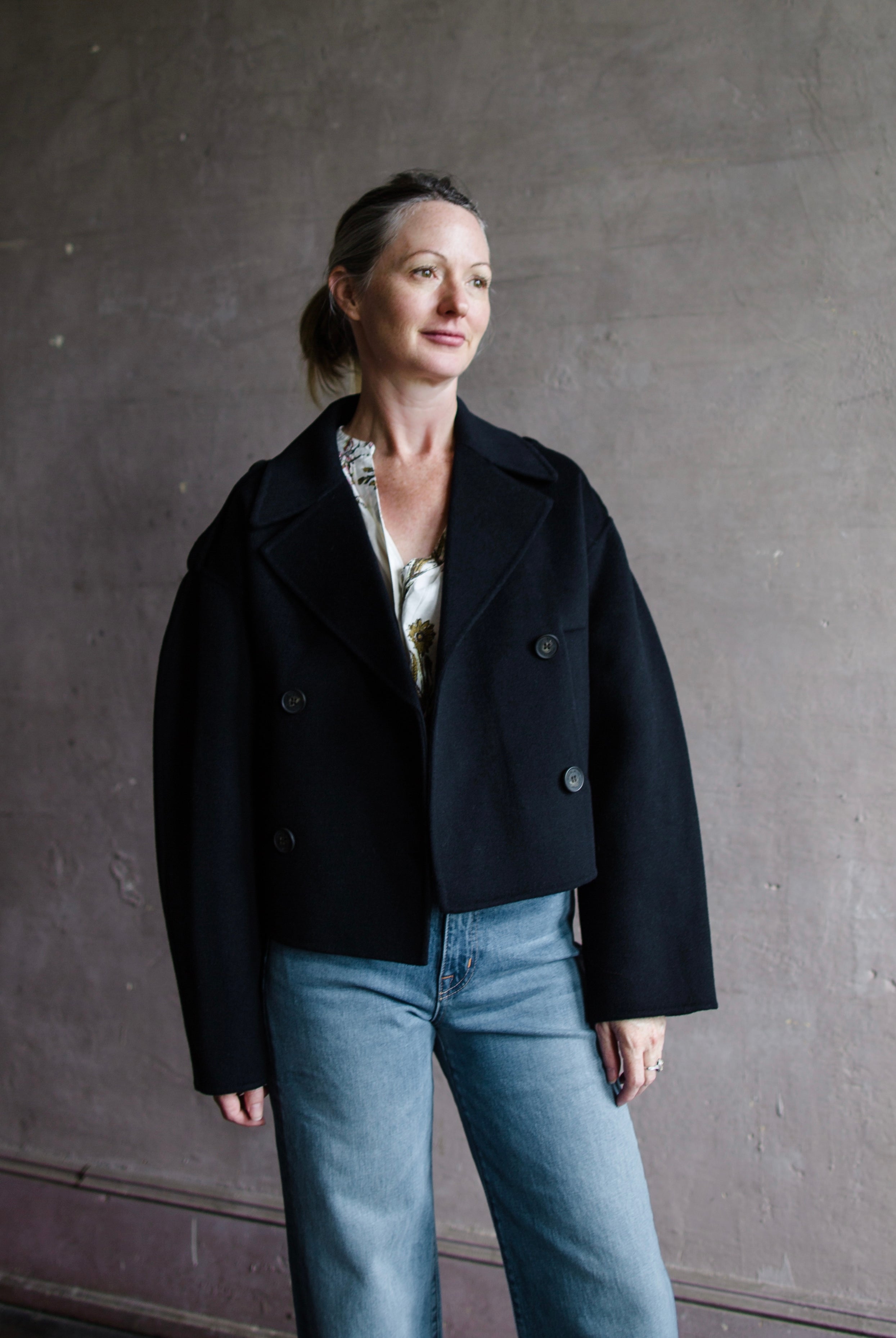 Image featuring a woman wearing the Beran jacket by Vanessa Bruno with double breasted button closure and a full sleeve with a slightly shorter fit in navy blue.