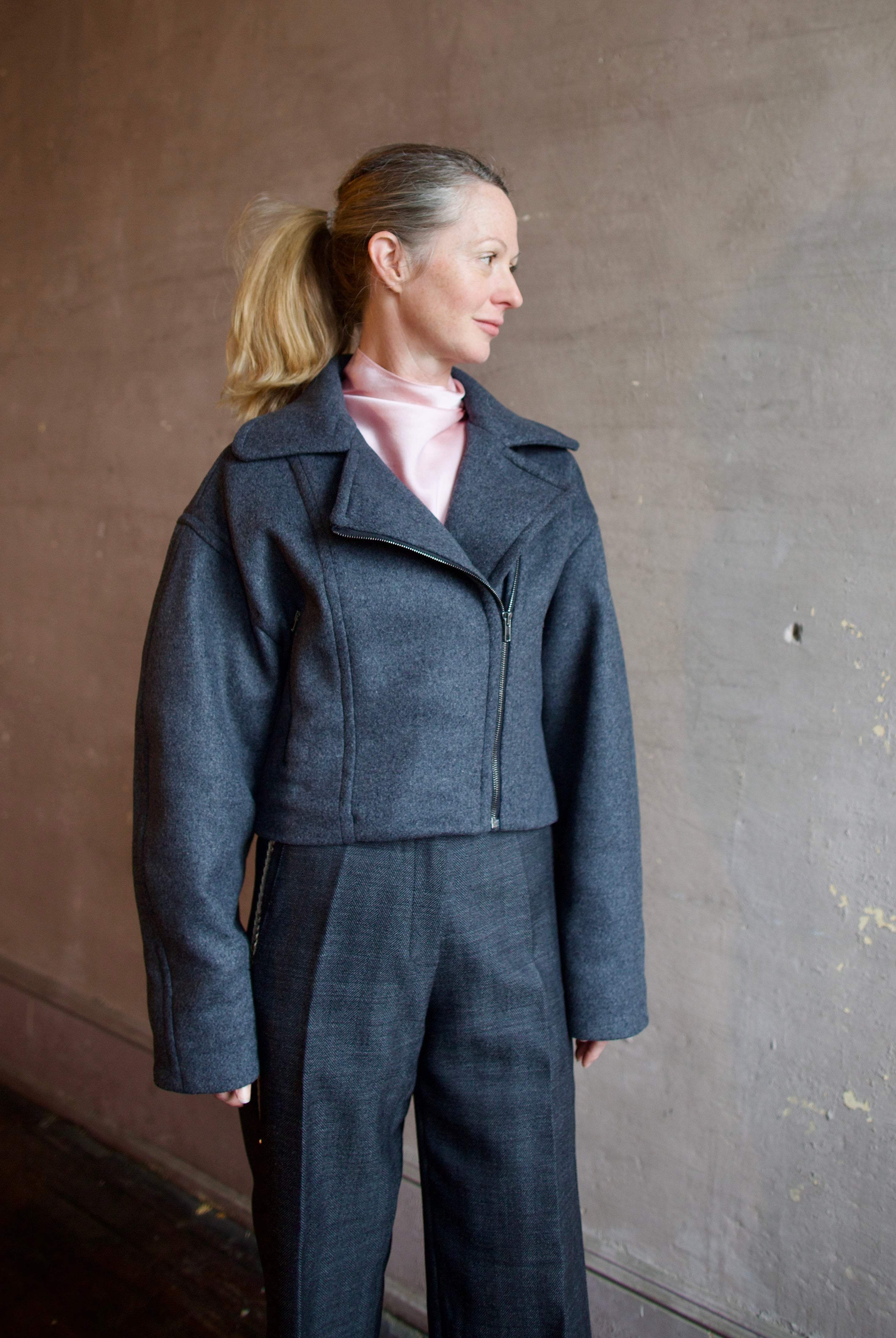 Image featuring a woman wearing the Bless jacket by Vanessa Bruno with an asymmetrical zipper, full sleeve and a slightly cropped fit in dark grey.