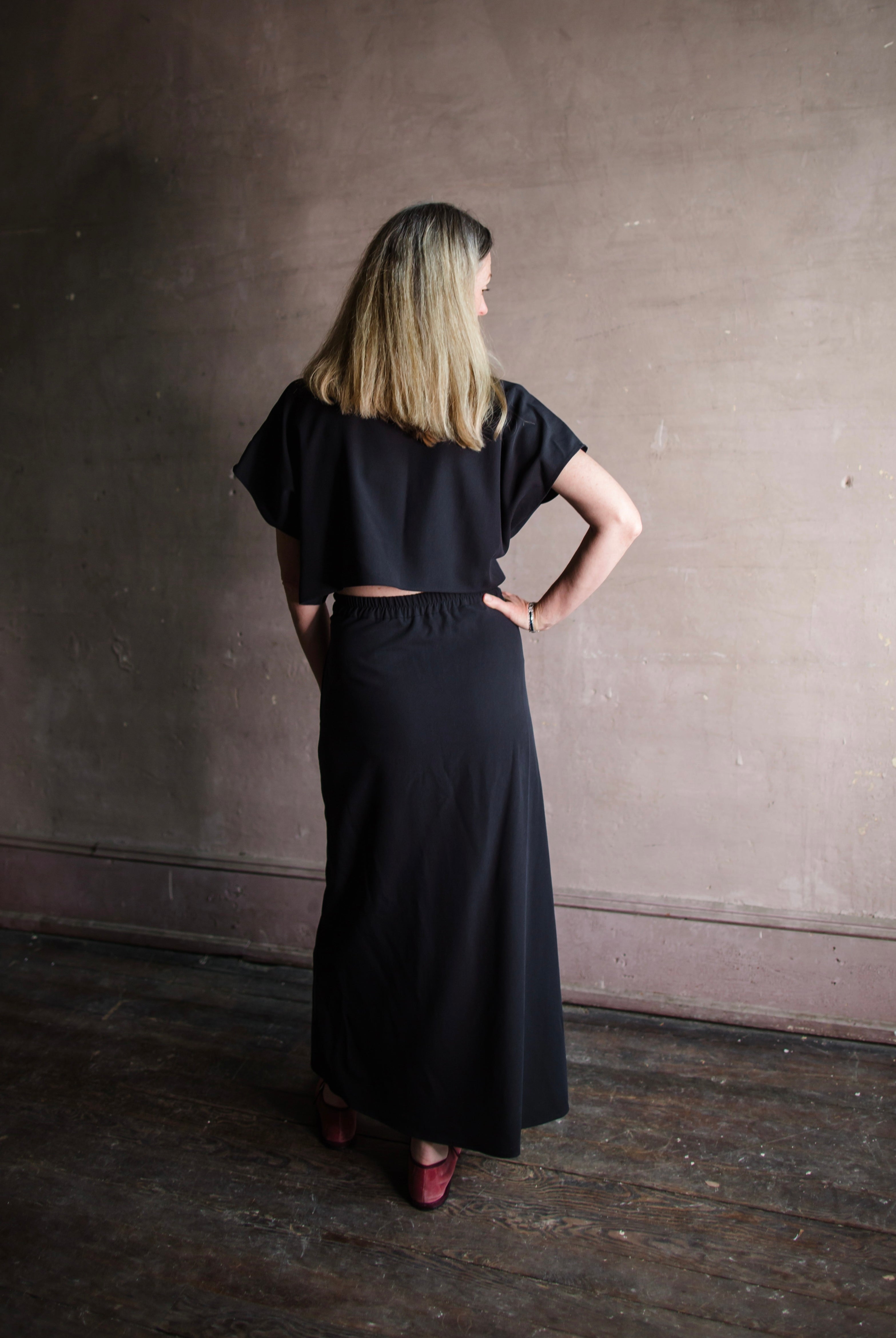 Image featuring a woman wearing the Cheryle dress by Vanessa Bruno in lyocell with a button front and tailored skirting with an open back in navy blue colorway.