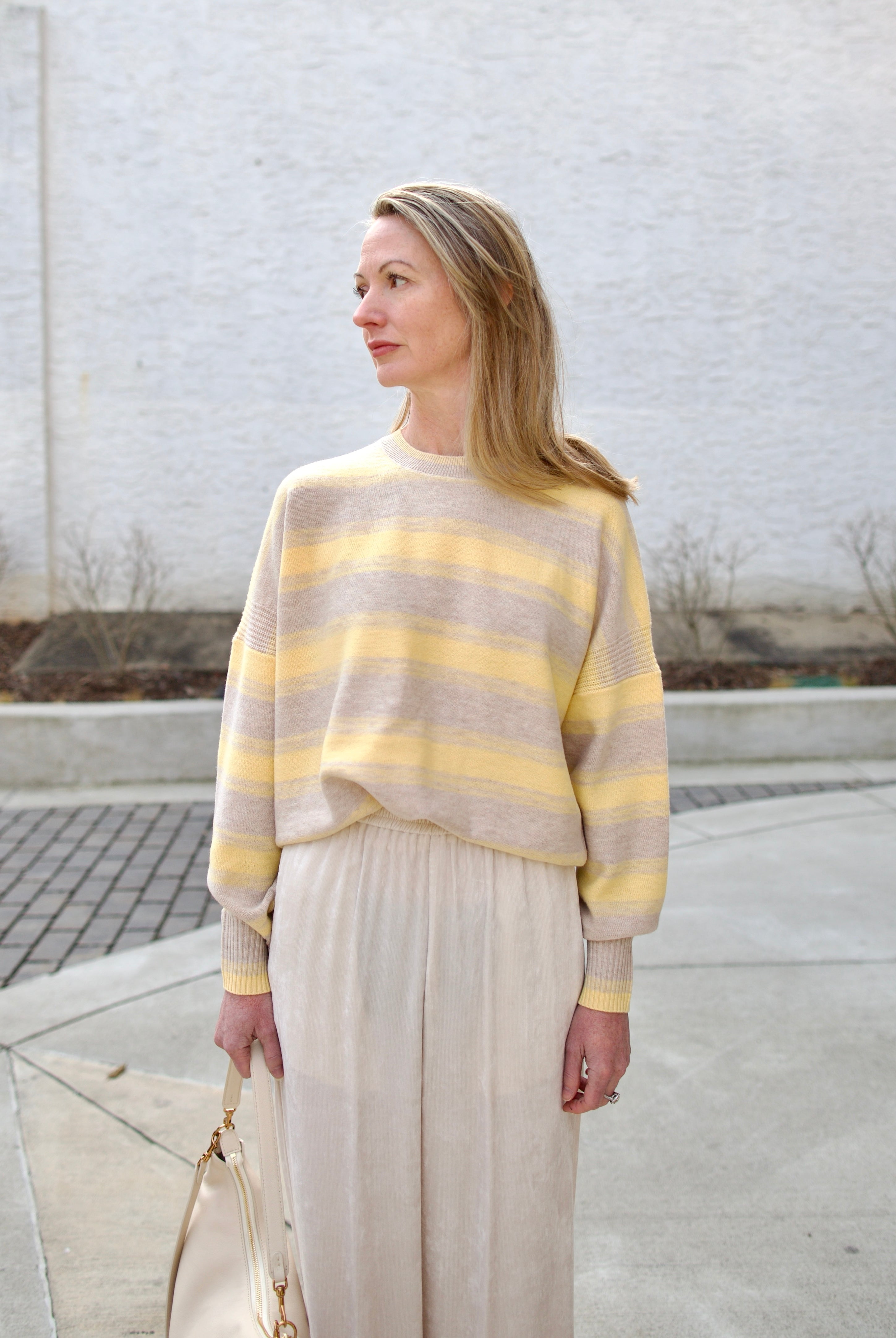 image of a woman wearing the vanessa bruno eugenie striped sweater, forte forte corduroy pants and mansur gavriel swing bag