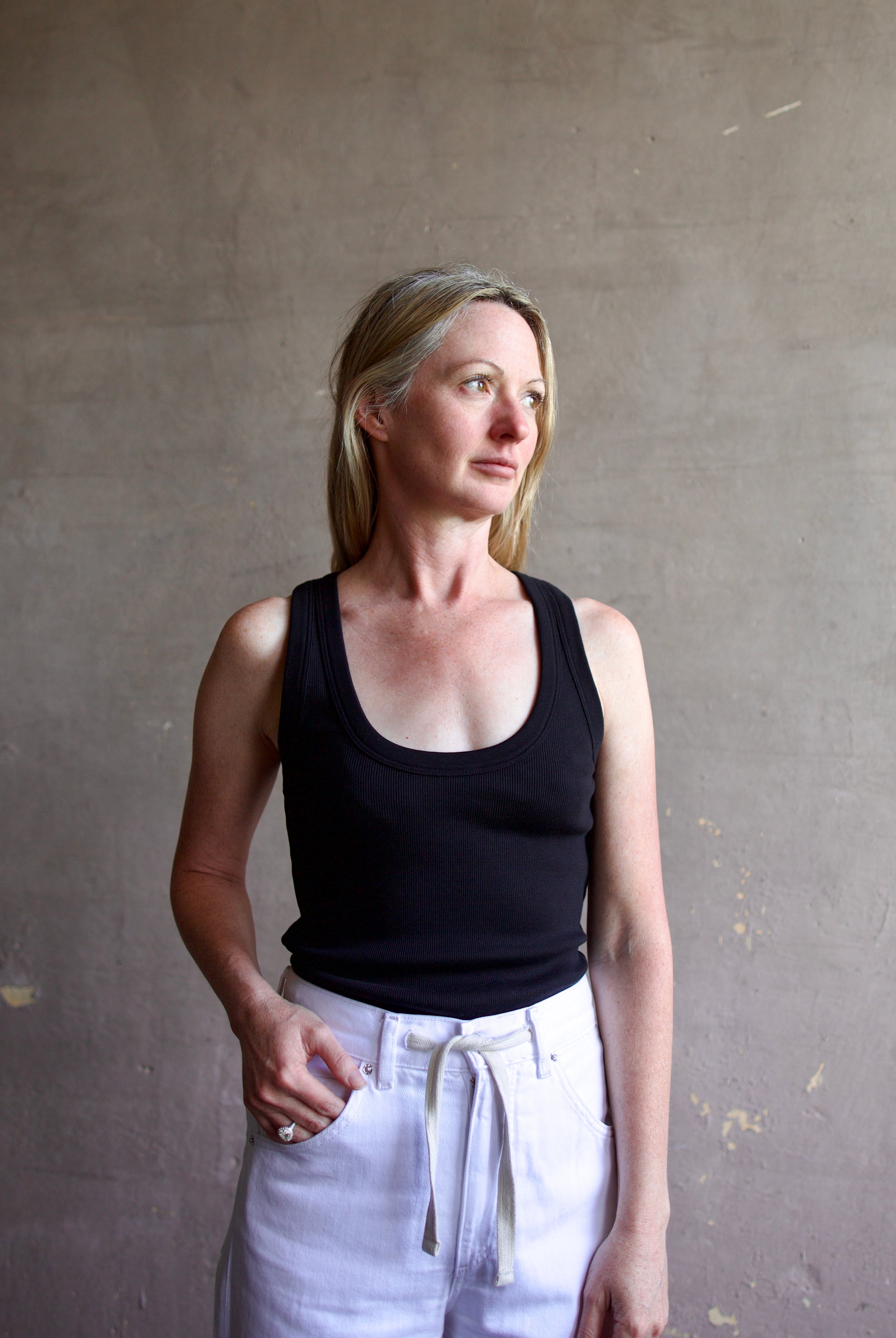 Image of a model wearing designer Veronica Beard Birke black tank top in premium cotton blend with ribbed texture and classic scoop neckline