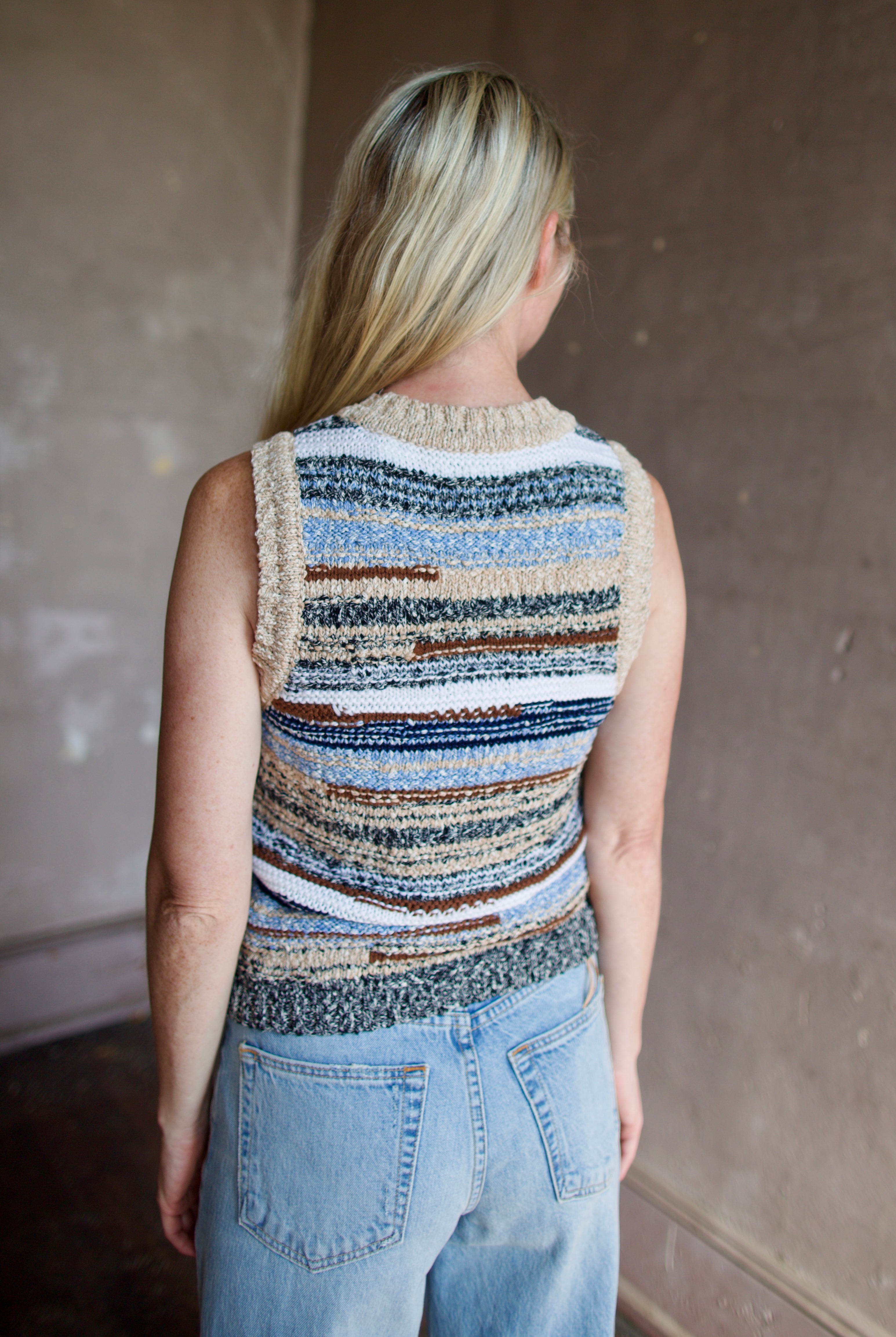 Model wearing a sleeveless, multicolored intricately woven knit top Jerrel in whisky by contemporary designer veronica beard