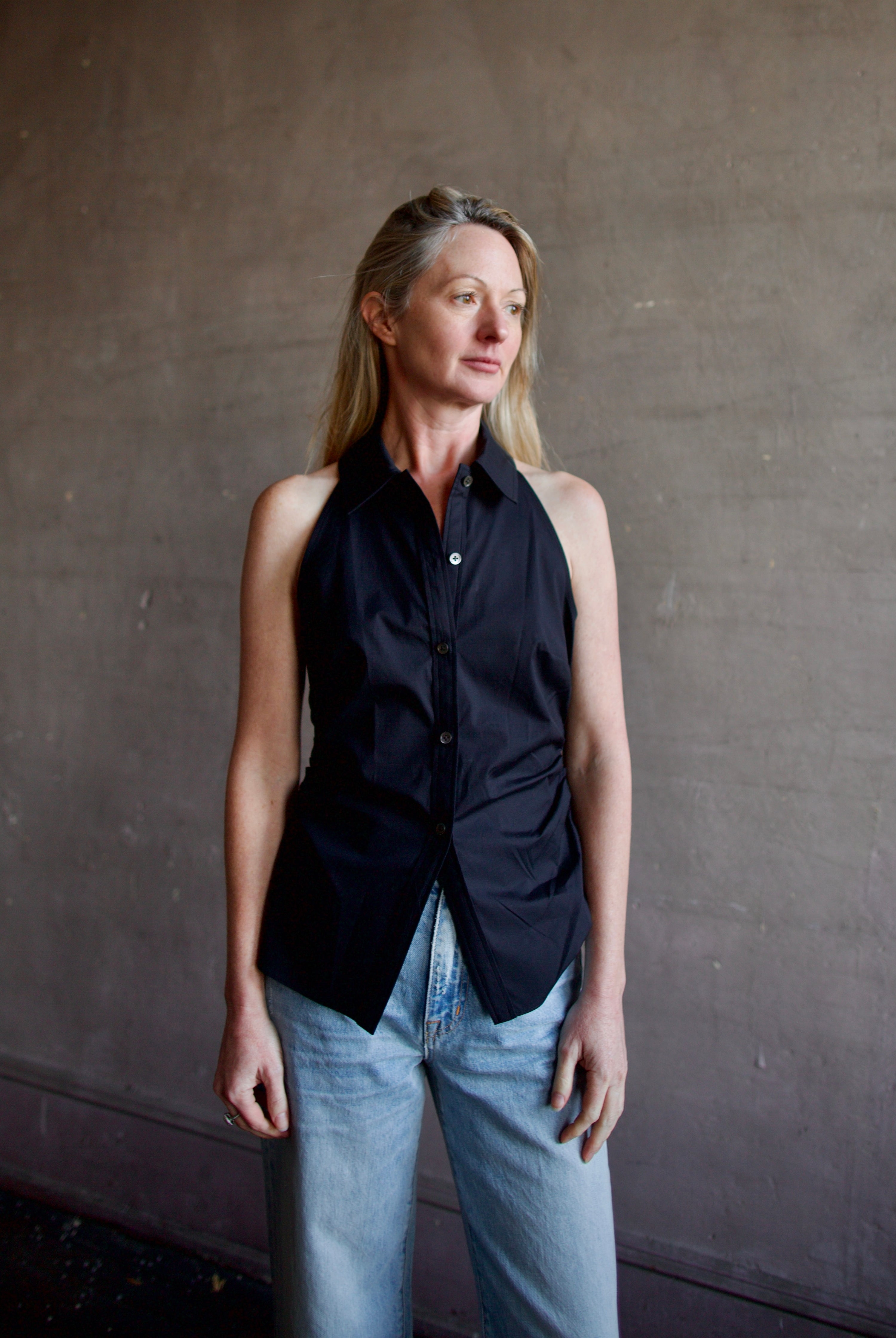 Mature woman wearing luxury women's black cotton blend Veronica Beard Regina Shirt with button front, collar, sleeveless, and tailored fit
