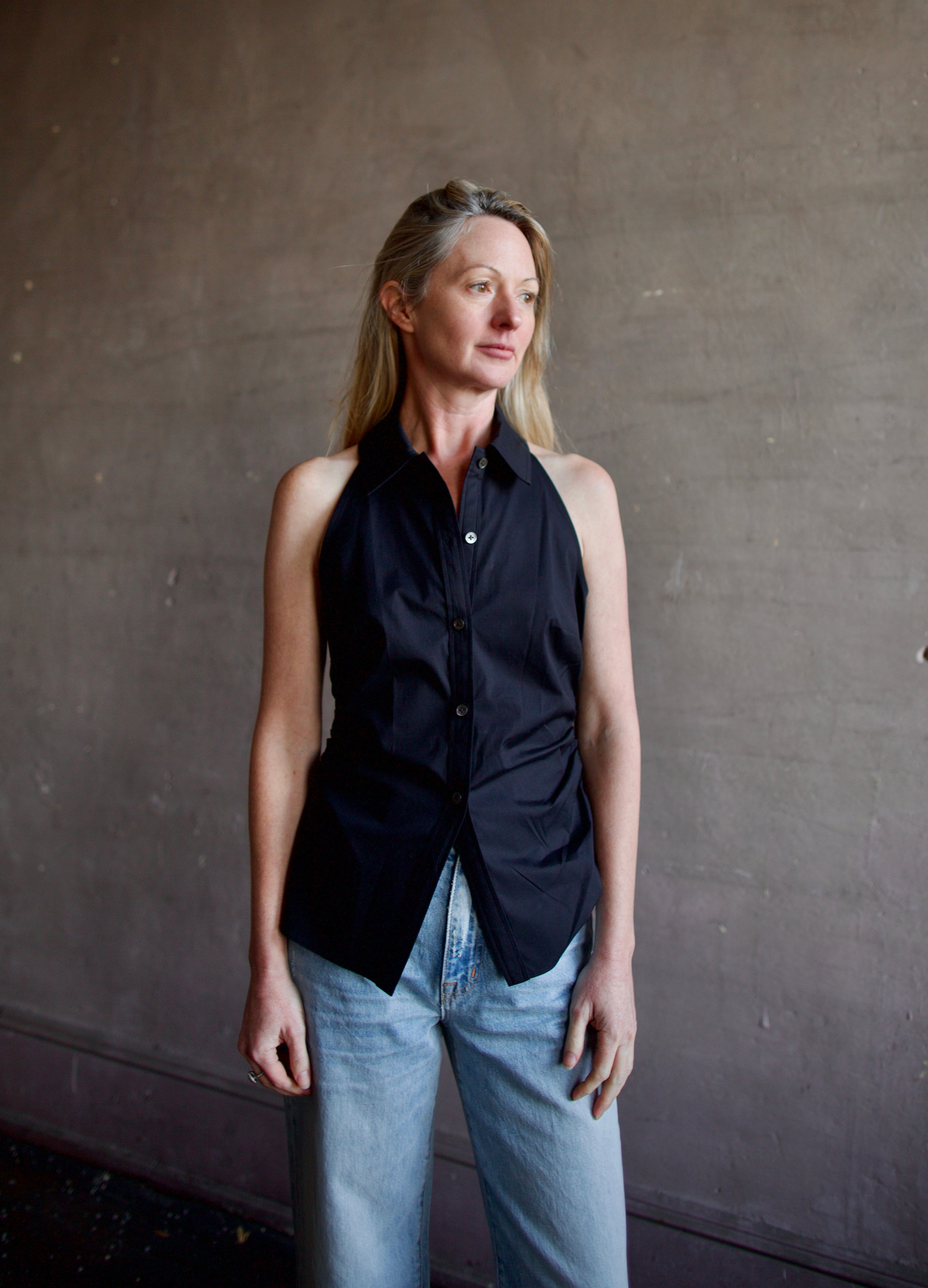 Mature woman wearing luxury women's black cotton blend Veronica Beard Regina Shirt with button front, collar, sleeveless, and tailored fit