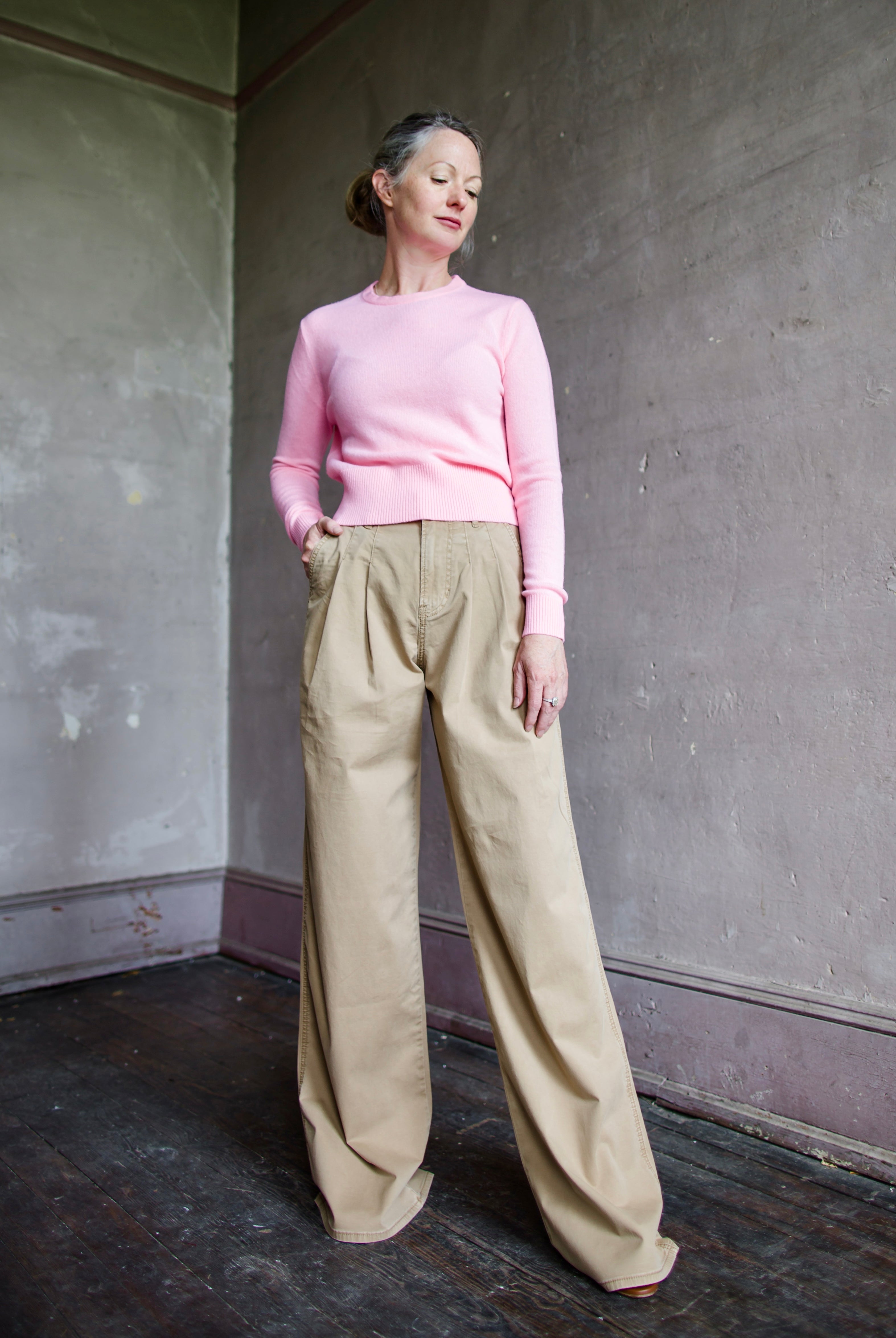 Image featuring a woman wearing the cotton blend Mia pants by Veronica Beard with a high rise, front pleats and a wide leg in Khaki.