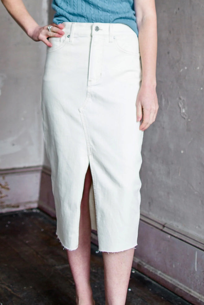 Mature woman wearing the Breves stretch denim pencil skirt by Veronica Beard in ecru with zip closure and front vent