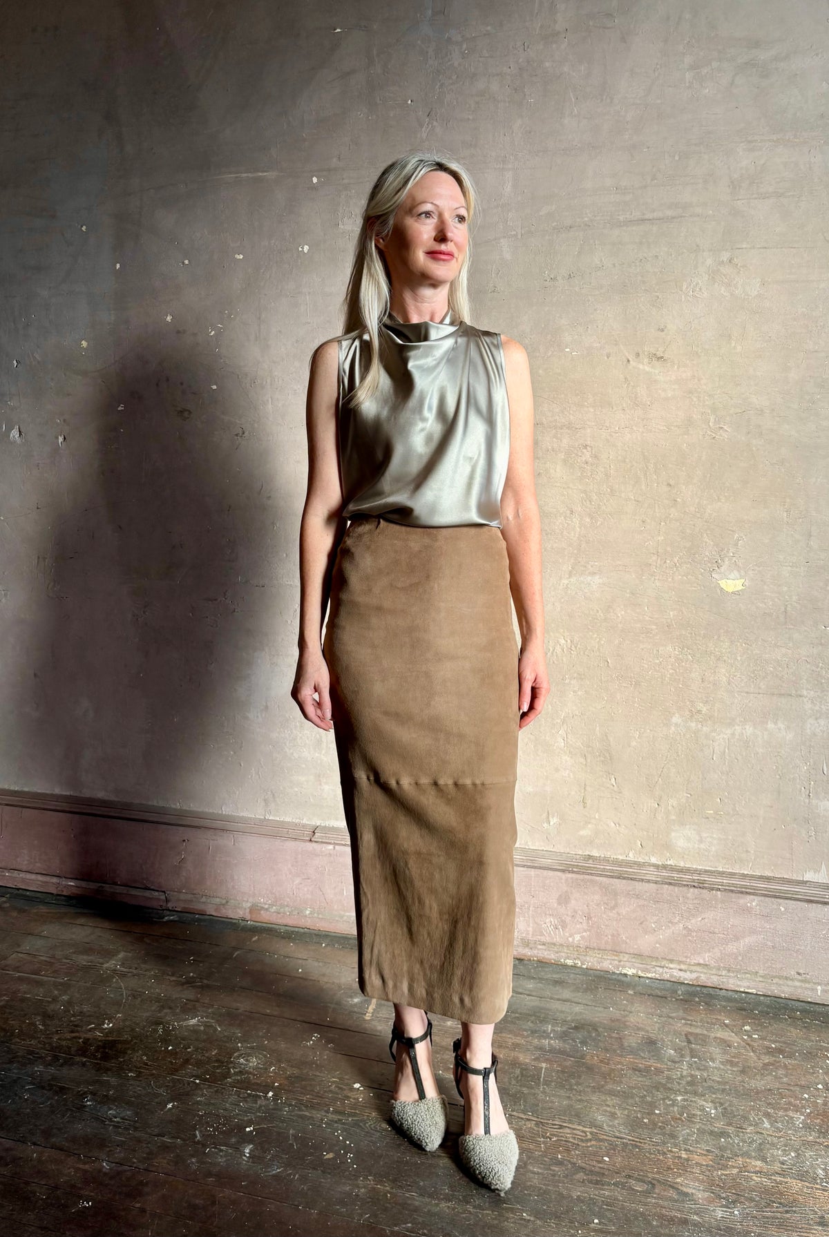 Mature woman wearing Veronica Beard Tam Silk Top in Pewter with a suede leather pencil skirt quietly luminous and occassion ready
