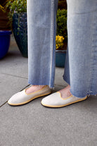 A pair of beige Vibi Venezia slippers with yellow grosgrain ribbon trim in premium linen construction and traditional Venetian slipper design