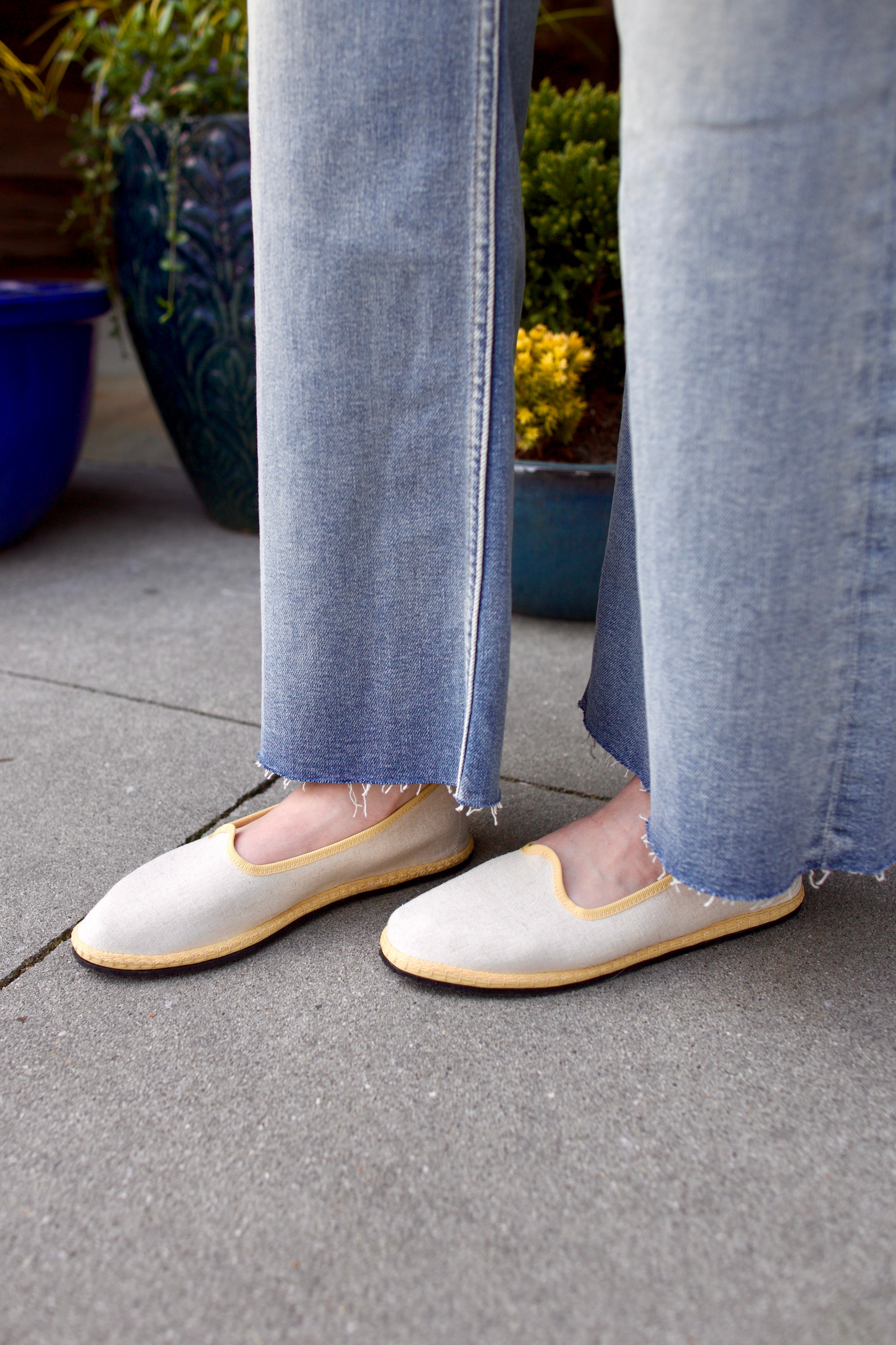 A pair of beige Vibi Venezia slippers with yellow grosgrain ribbon trim in premium linen construction and traditional Venetian slipper design