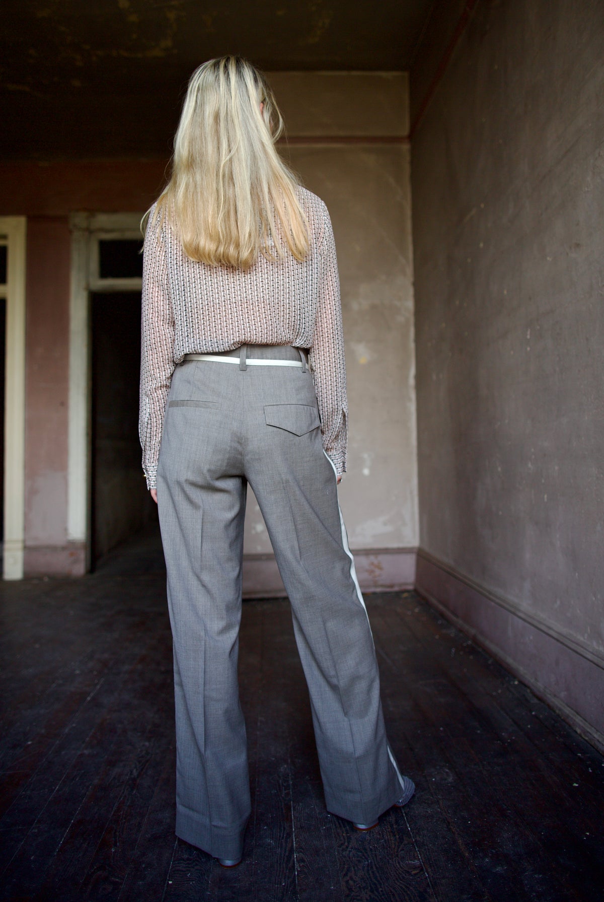 Mature model wearing virgin wool taupe tuxedo trousers with cream details by luxury designer WE-AR4