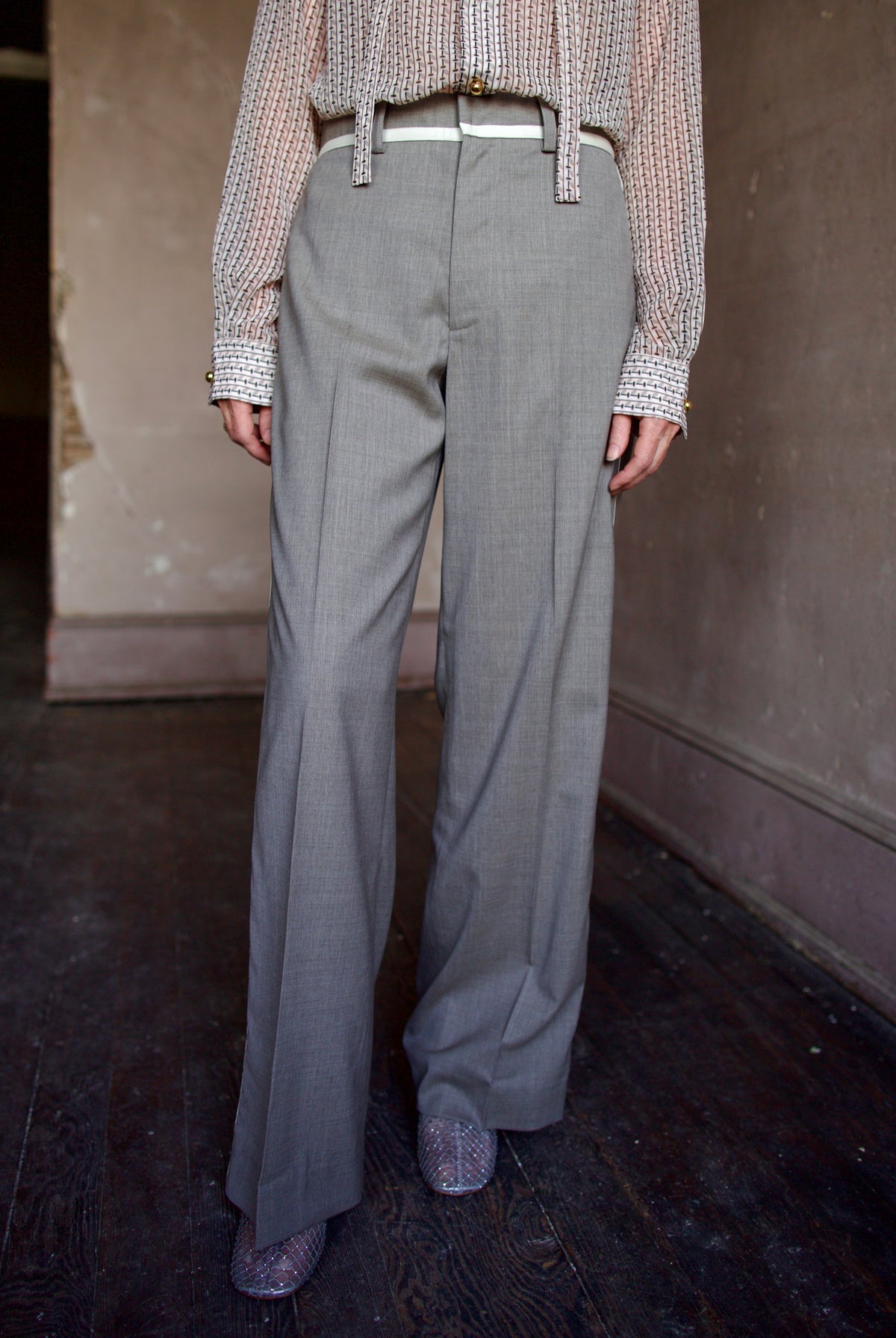 Mature model wearing virgin wool taupe tuxedo trousers with cream details by luxury designer WE-AR4