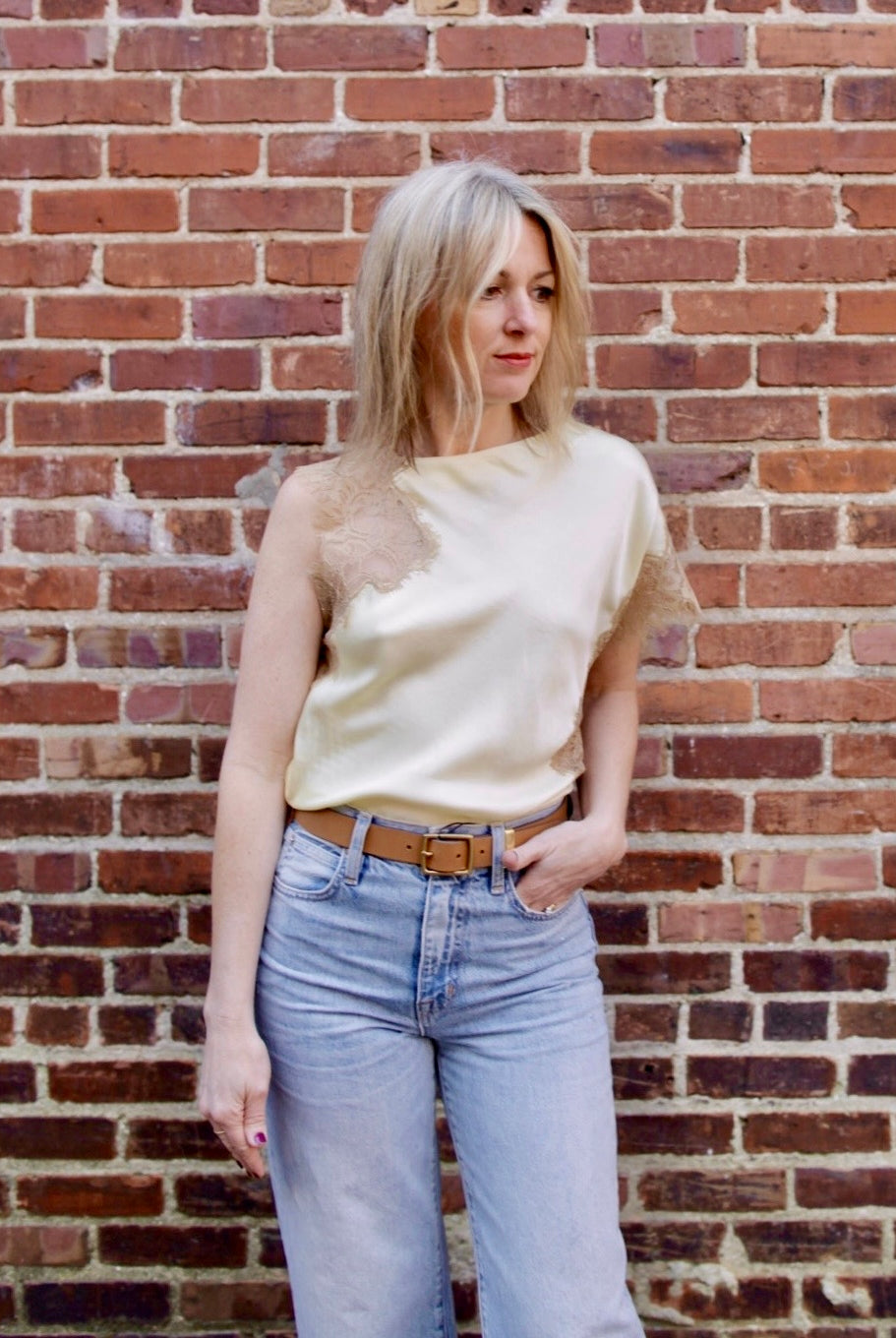 Mature woman wearing the yellow and beige ALC Alessia Top with open neckline, asymmetrical fit and lace detailing