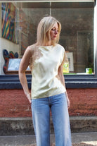 Mature woman wearing the yellow and beige ALC Alessia Top with open neckline, asymmetrical fit and lace detailing