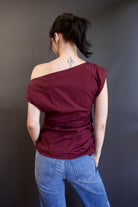 Back of ALC Nara top in burgundy with one-shoulder asymmetrical design and rushing at waistline