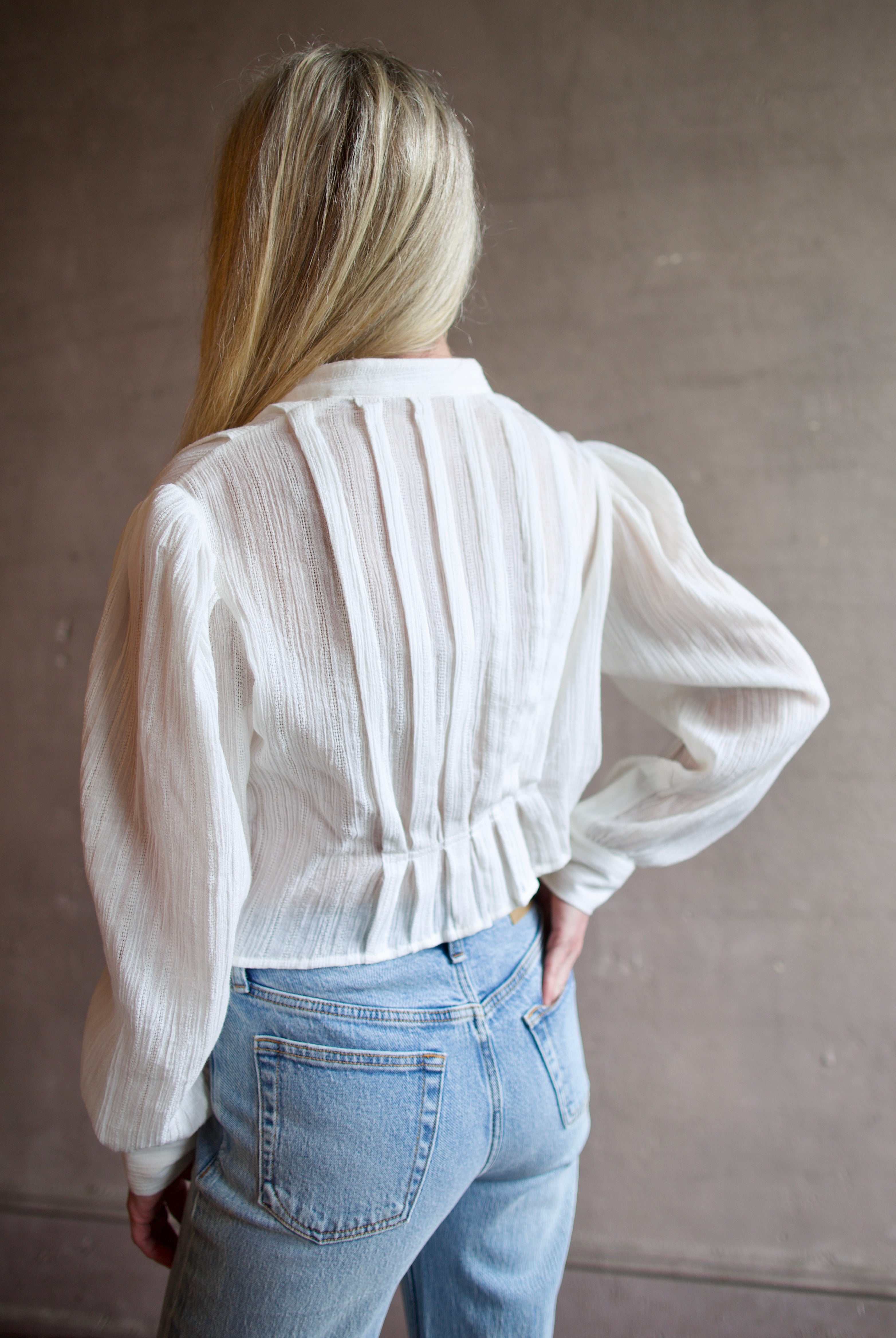 Model wearing the Alix of Bohemia Ryland Pearl Dobby Shirt with elegant pleating details in a comfortable white cotton construction